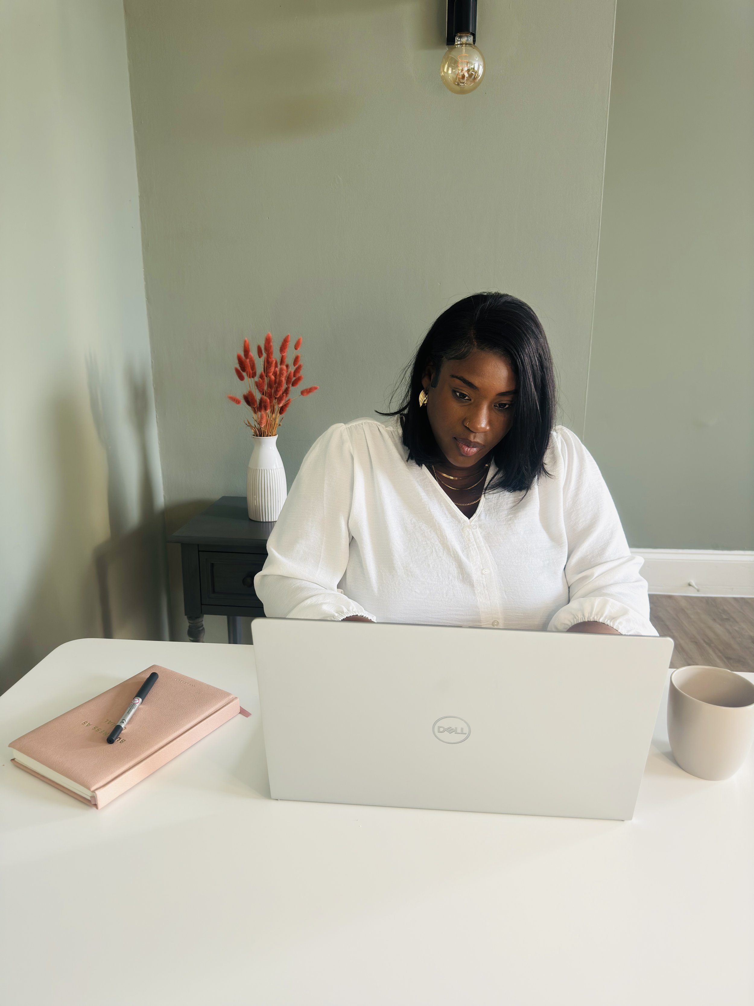 Bonita Carmel working at her desk, reflecting and creating in a calm, light-filled space — a moment that reflects the thoughtful, compassionate approach behind Carmel Coaching.