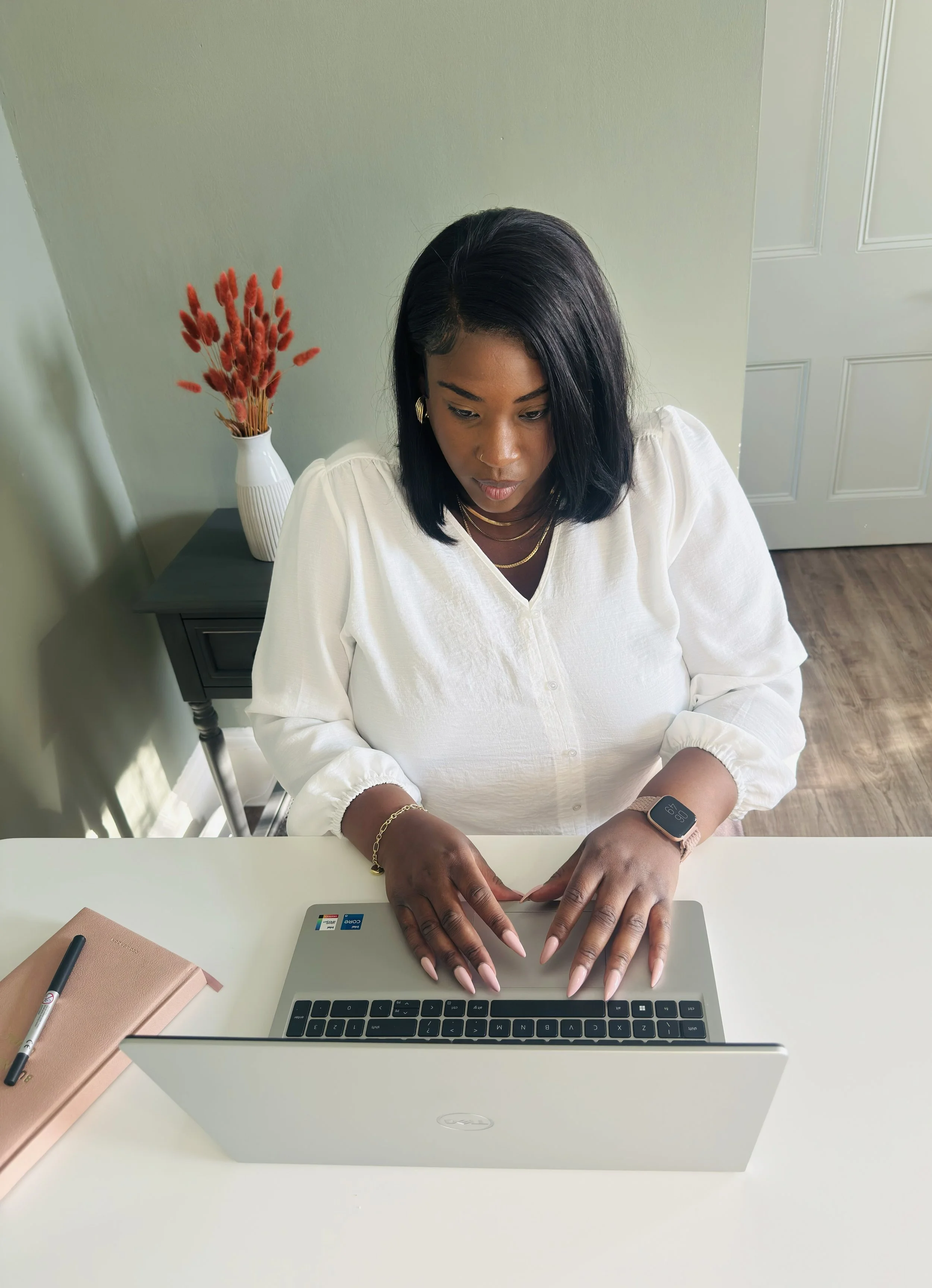 Bonita Carmel working at her laptop, creating a welcoming space for prospective clients to reach out, ask questions, and take the first step towards self-acceptance and personal growth.