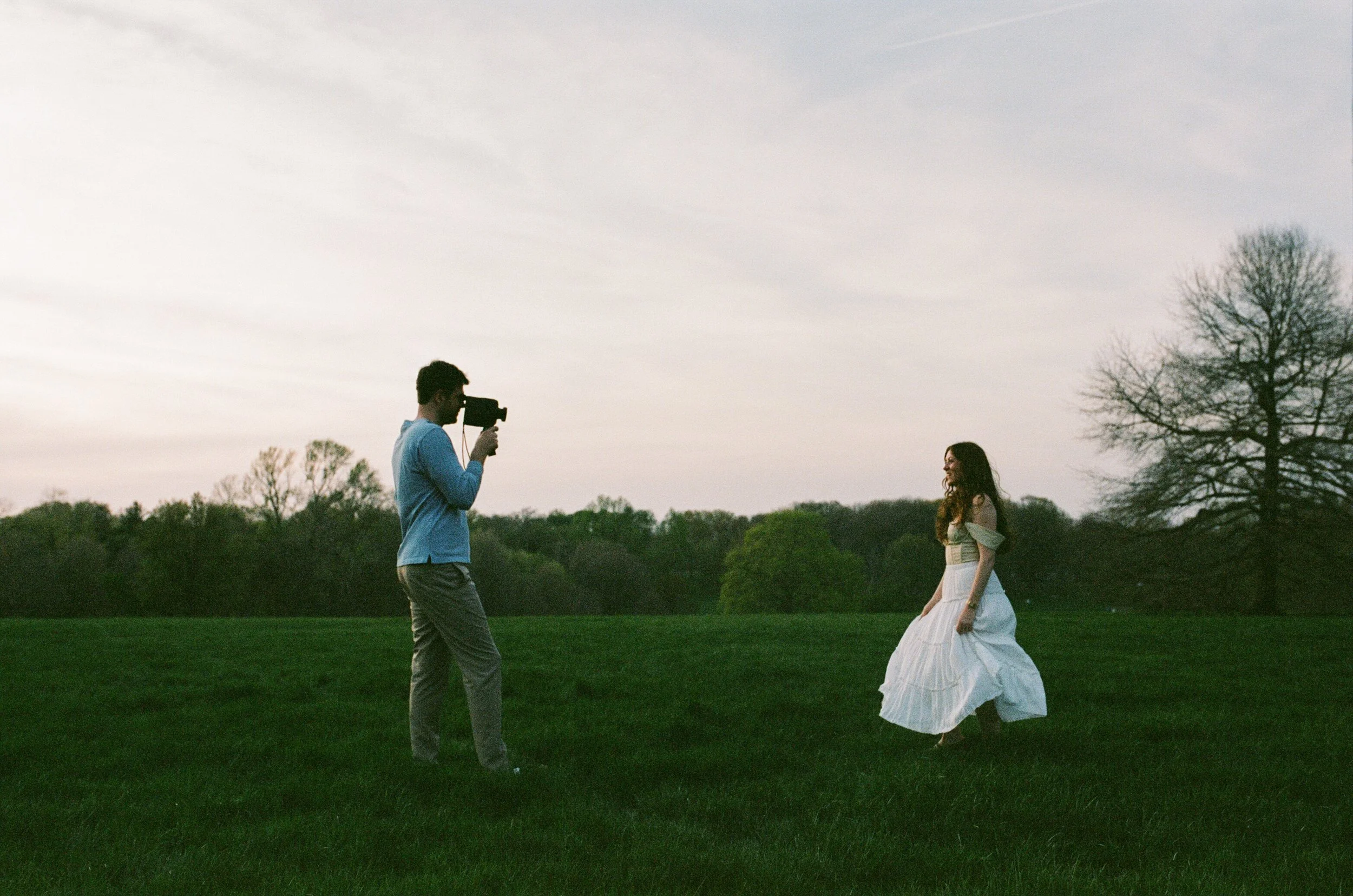 Photo of a couple at Loose Park in Kansas City, taking a Super 8 video of each other.