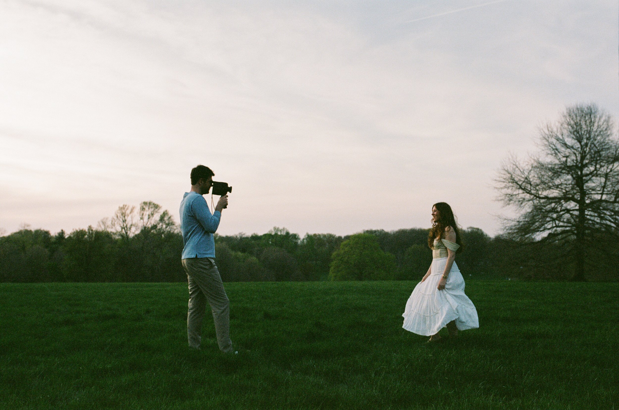 Photo of a couple at Loose Park in Kansas City, taking a Super 8 video of each other.