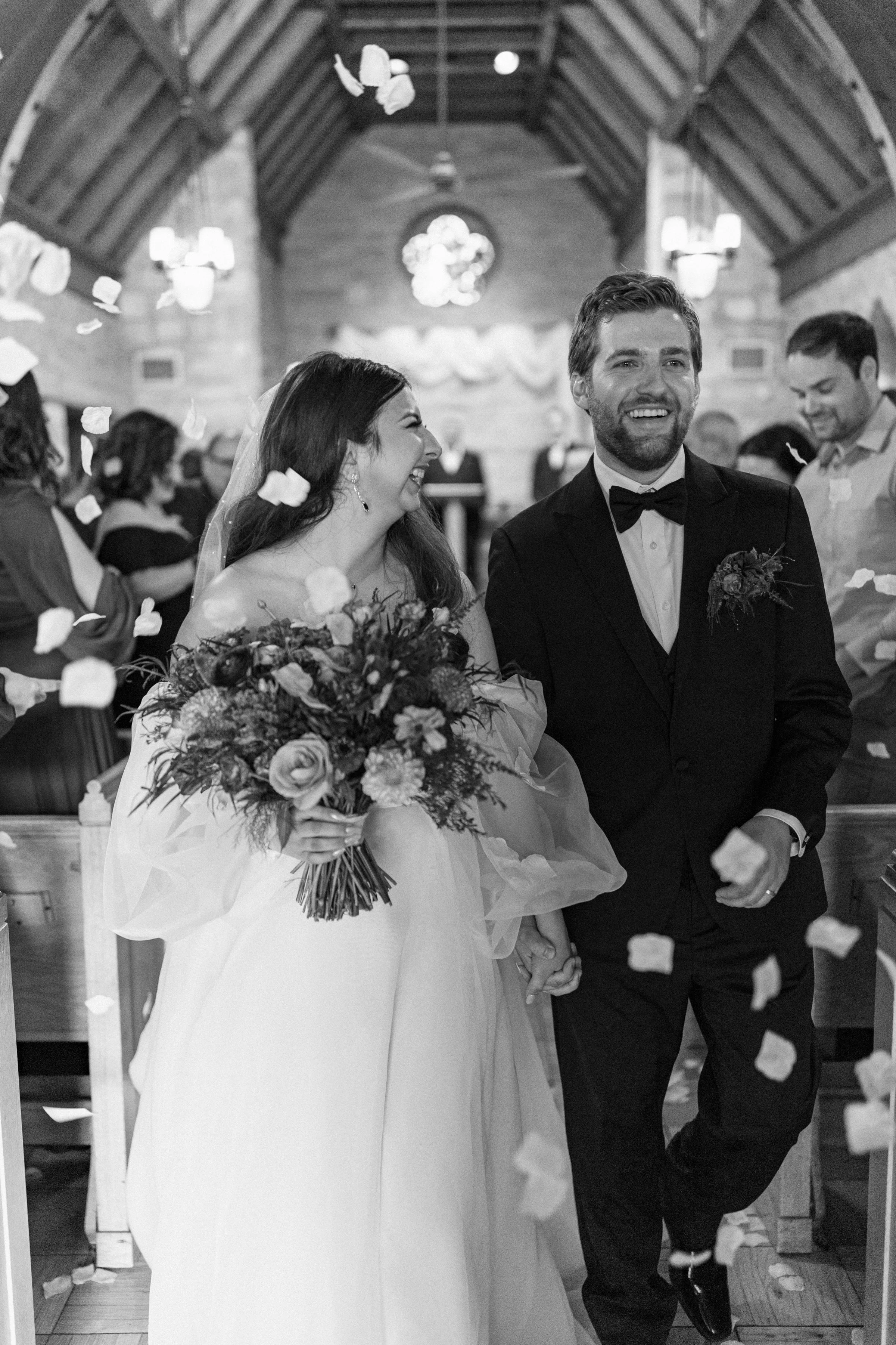 Couple being showered with flower petals after their wedding ceremony.