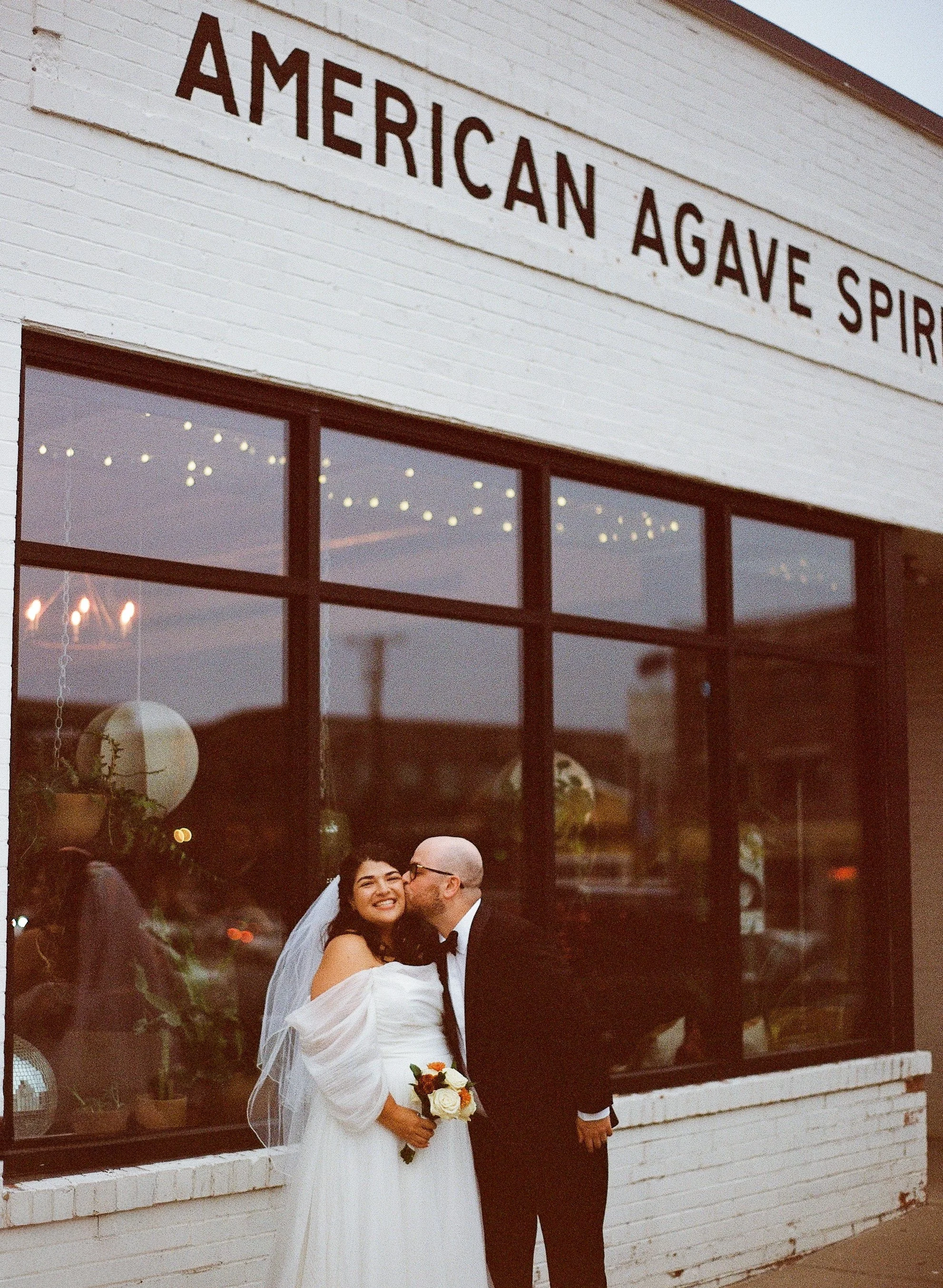 Photo of a bride and groom celebrating their wedding outside if Mean Mule Distillery