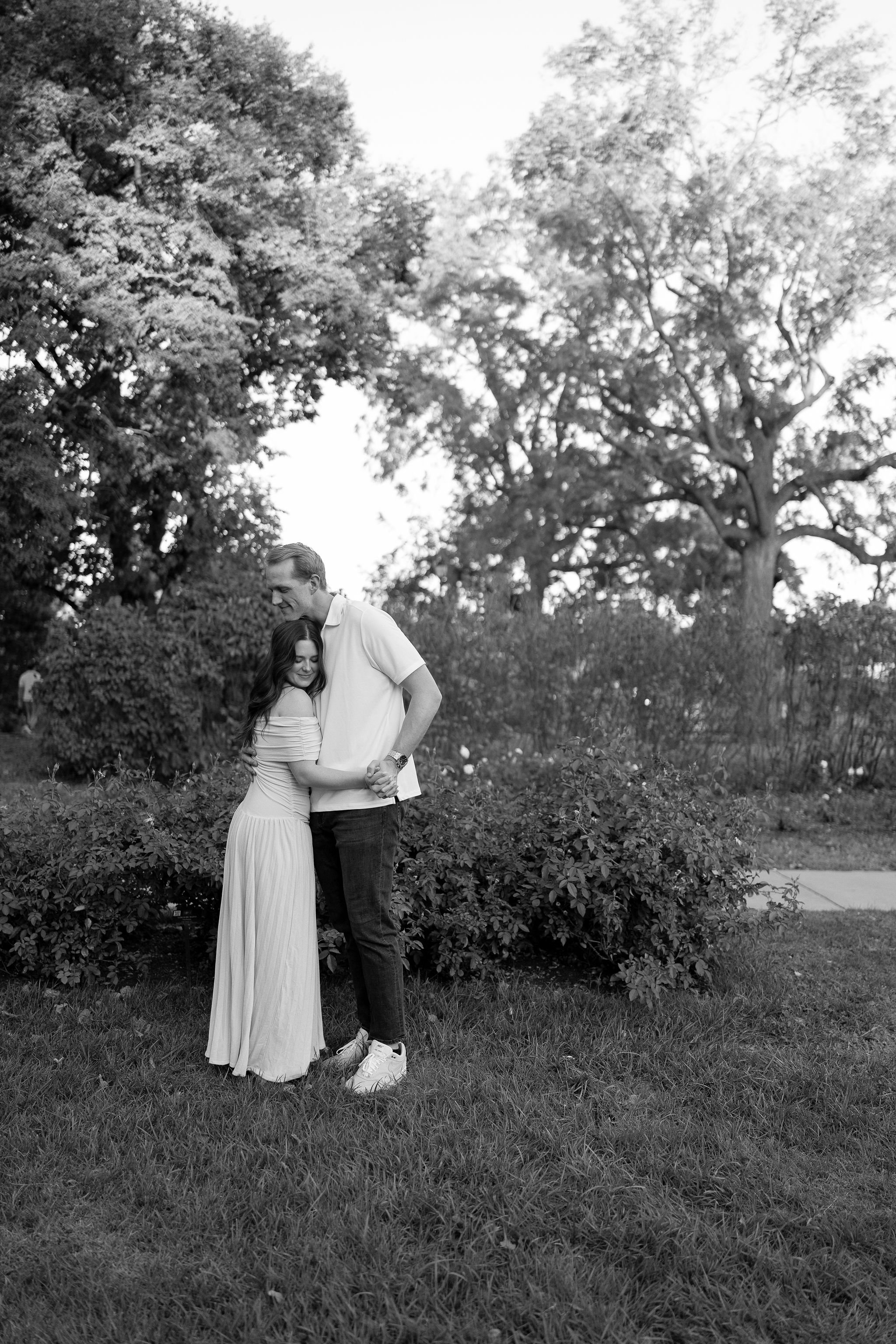 Couple taking photos in the rose garden at loose park.