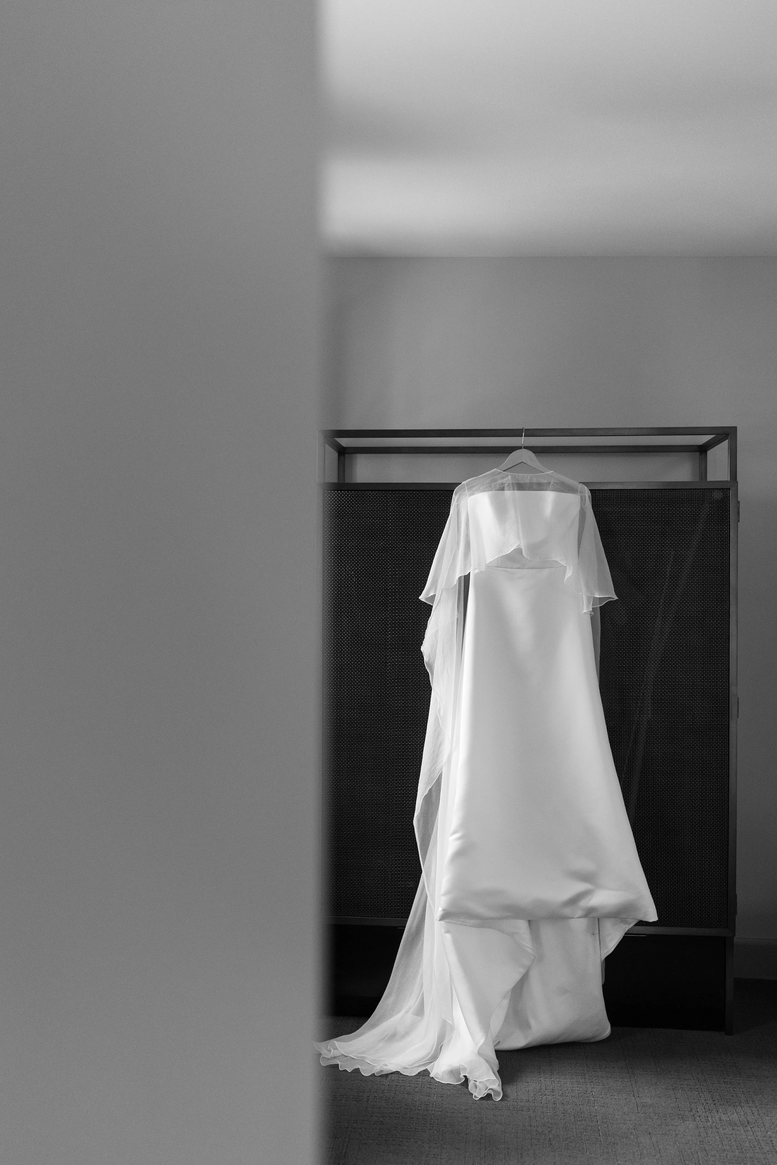 Elegant wedding dress and cape hanging up at Hotel Phillips