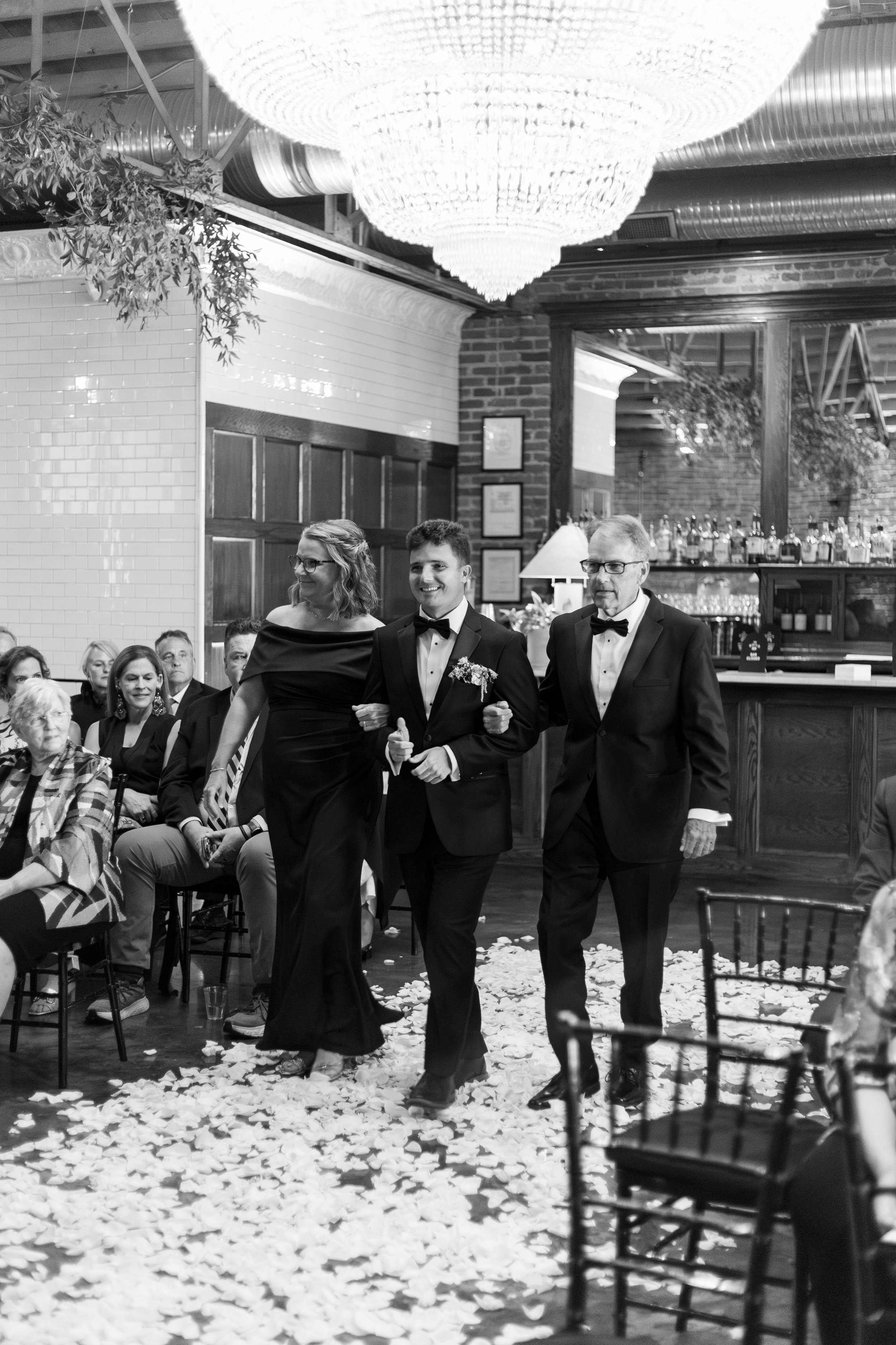 Tom and his parents has he walks down the aisle.