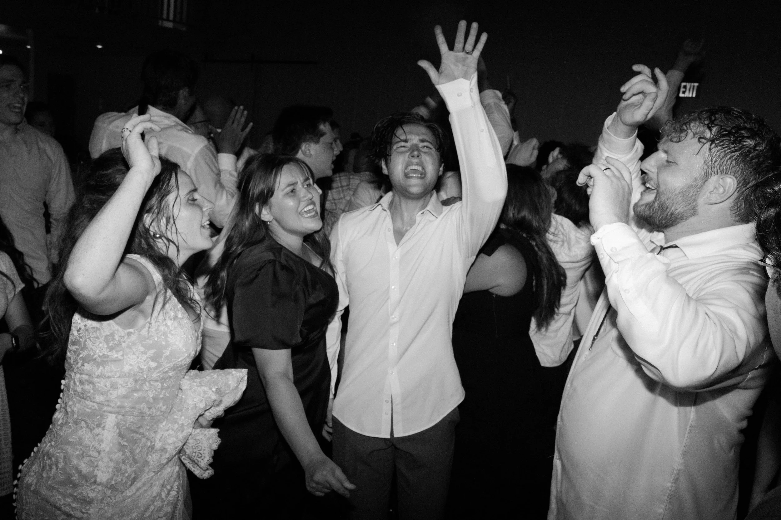 People dancing and singing passionately at a crowded celebration or party picture in black and white.