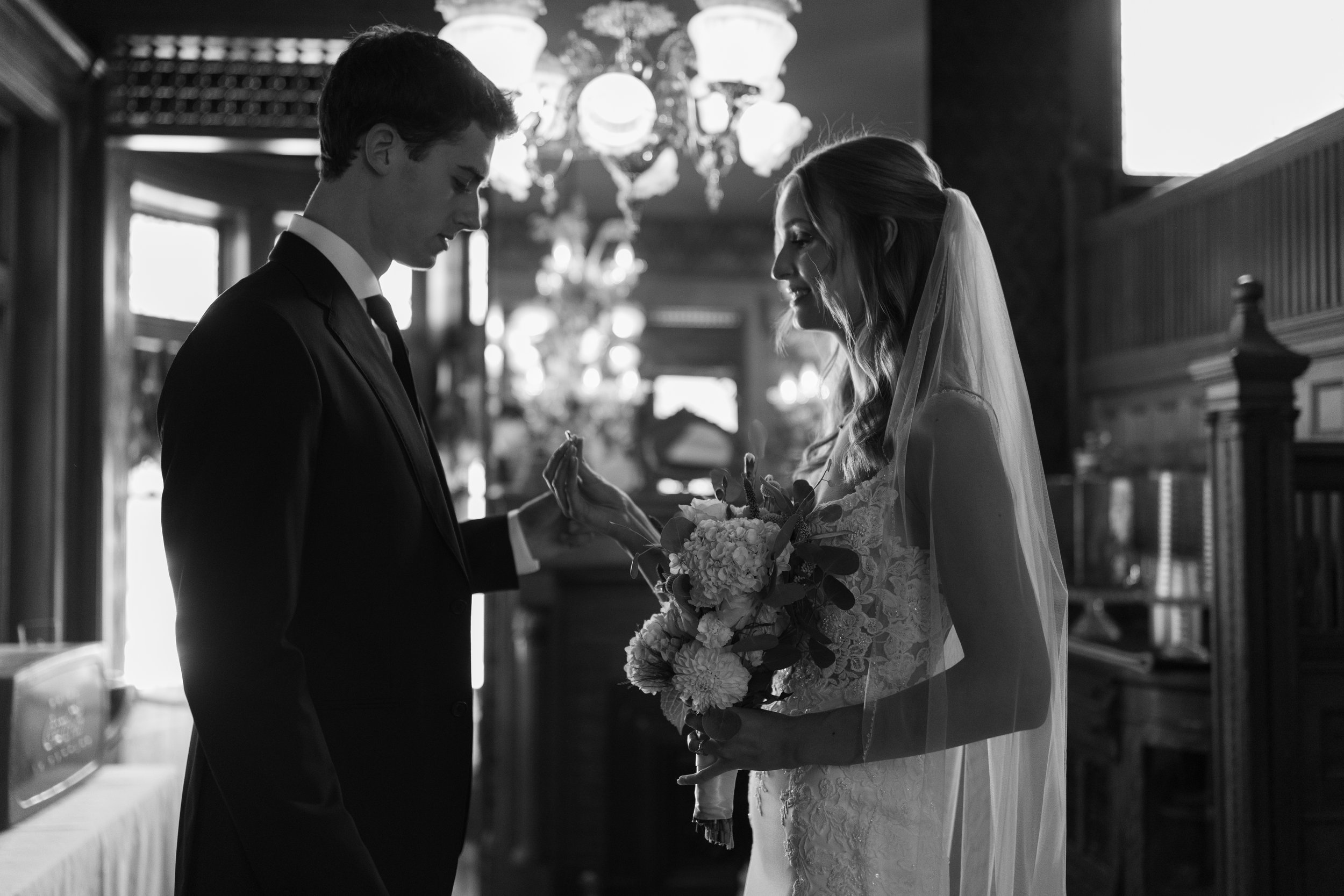 Megan, a bride, gives her groom his wedding ring during their first look at The Kansas City Mansion.