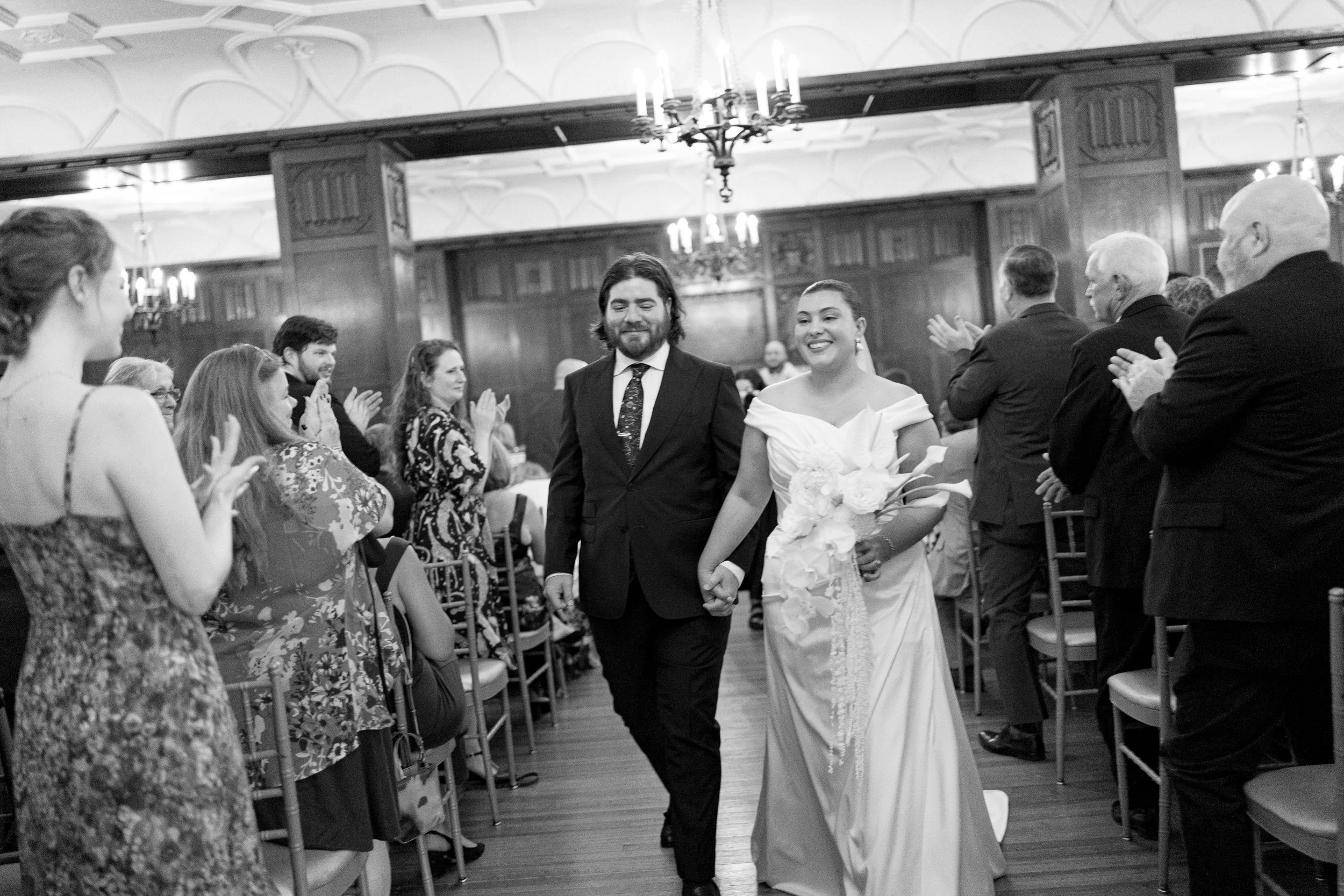 A newly married couple walks down the aisle after their ceremony at Hotel Kansas City