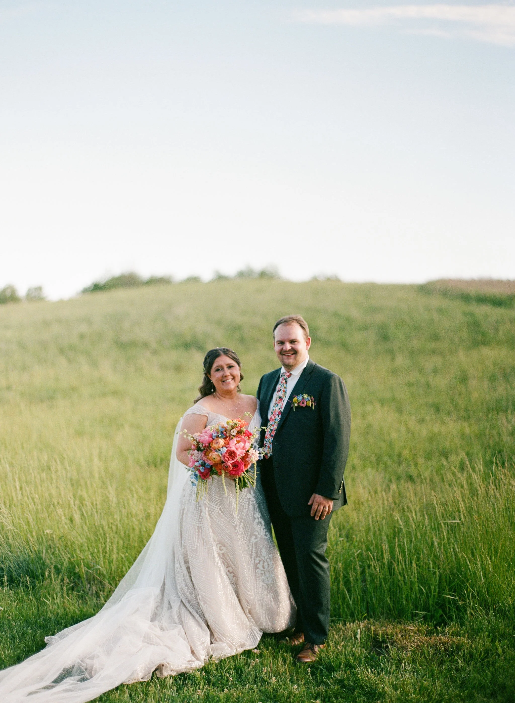 Photo of a couple in their wedding attire on the hills of Powell Gardens.