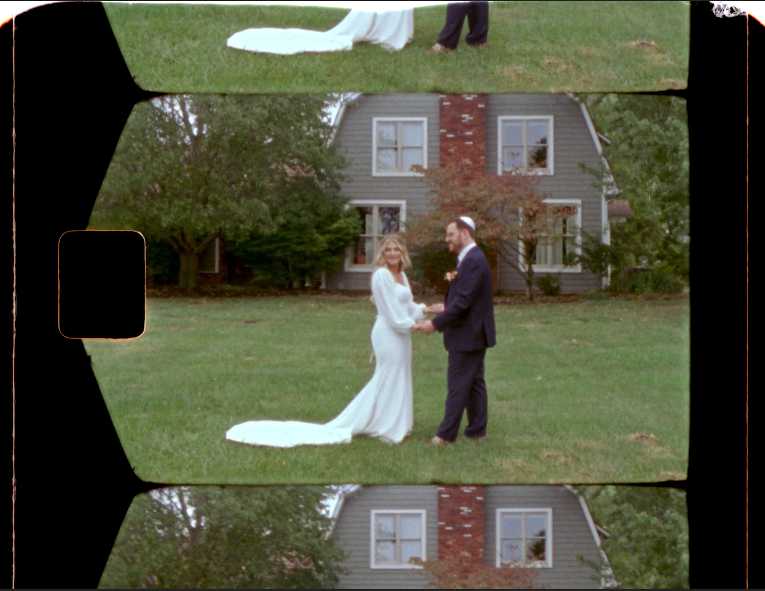 A bride and groom holding hands outdoors in front of a house, celebrating their wedding day.