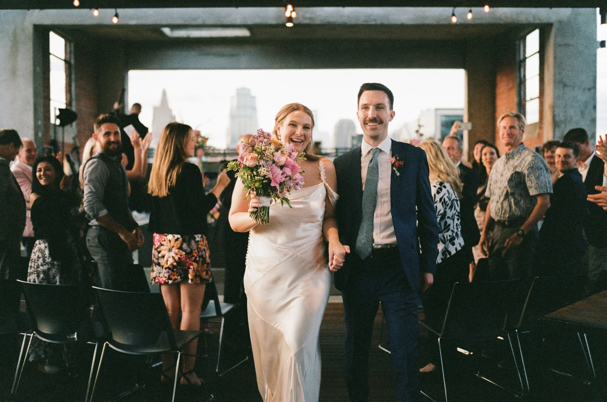 Photo of a bride and groom walking ack down the aisle after getting married at corrigan station.