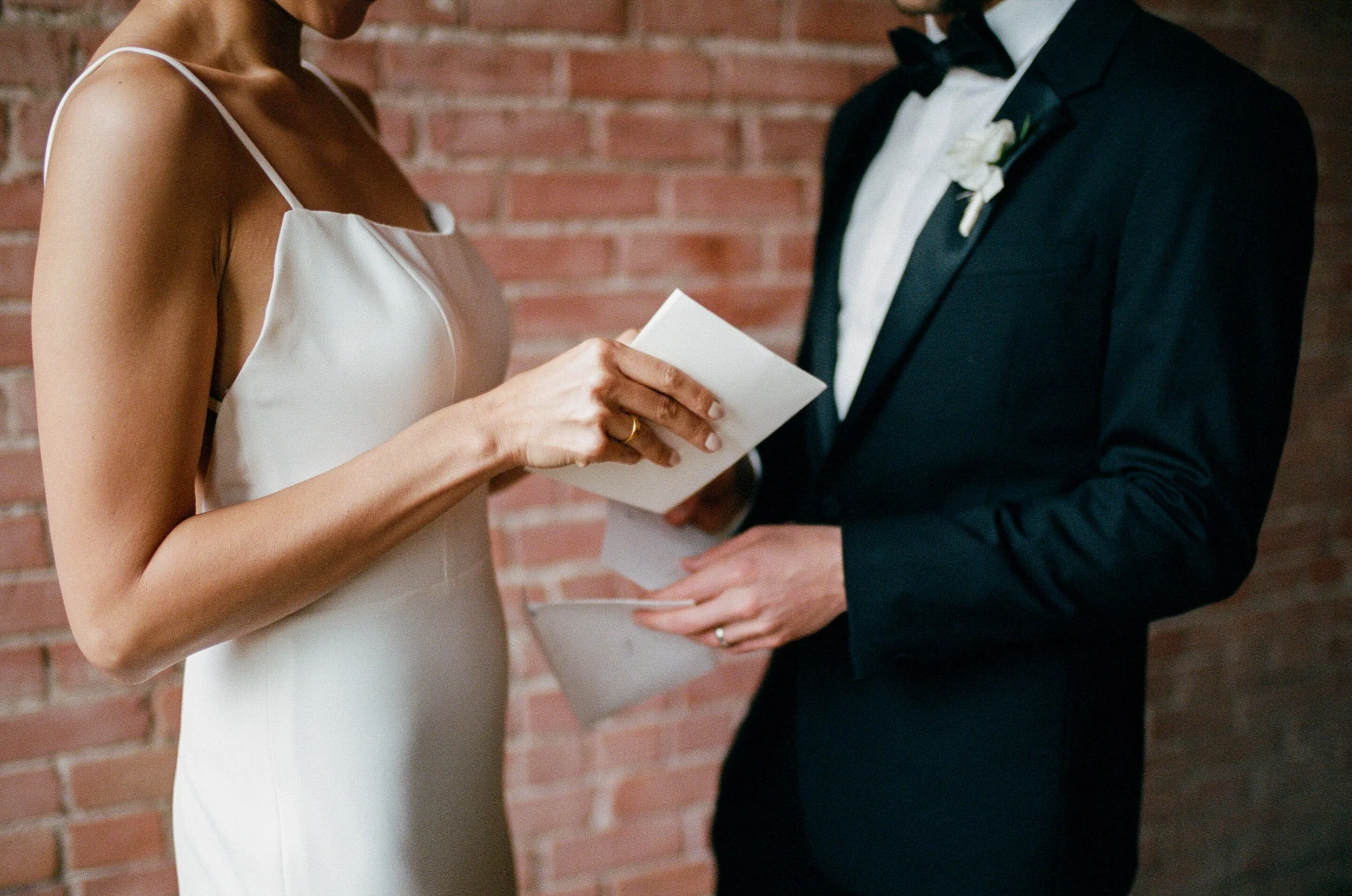 35mm film photograph of a couple with their vows written on paper