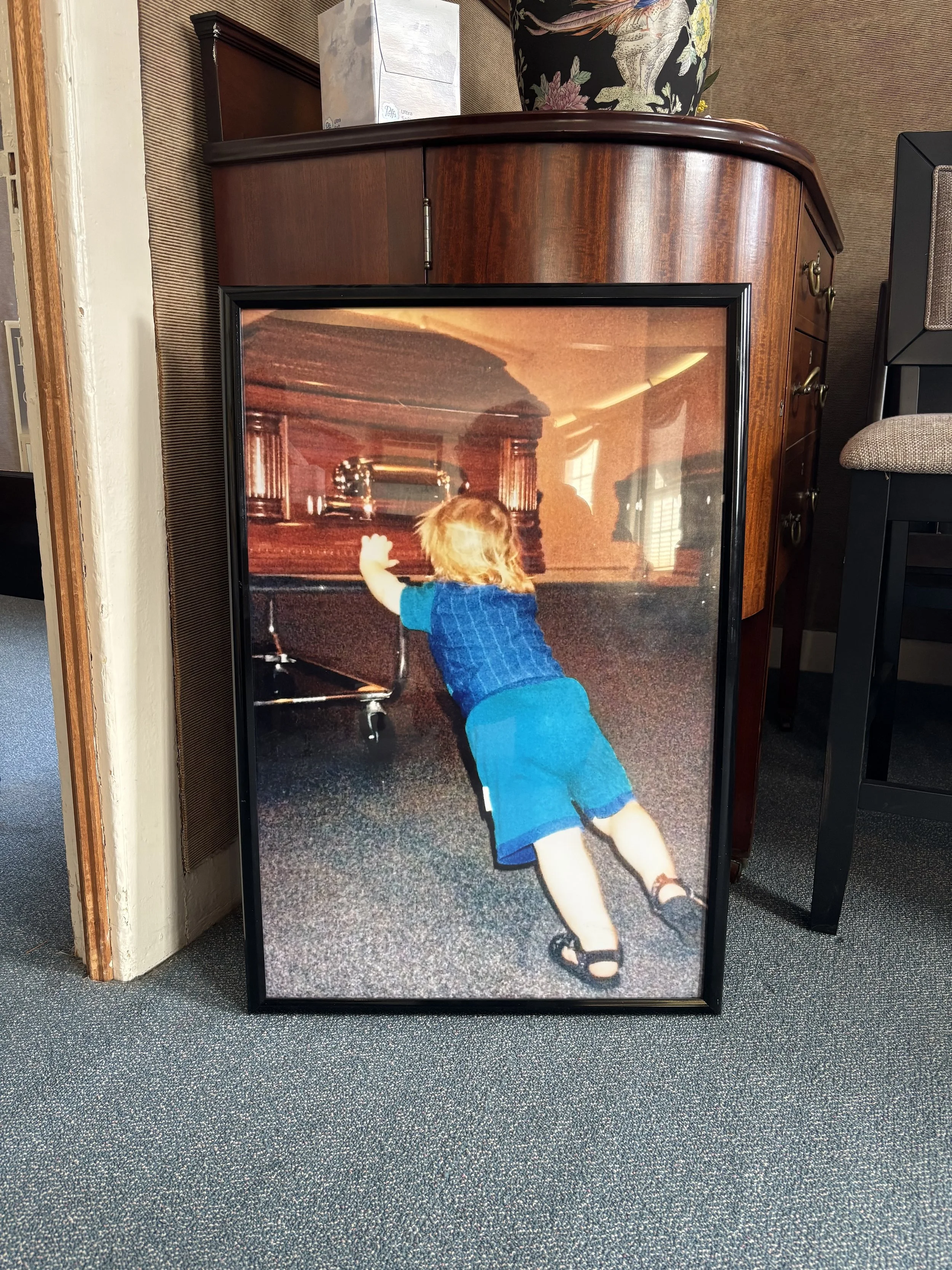 Jordan Camp at age 3, helping to move a casket in the funeral home. Today he's in his 30s, and helps run the place.