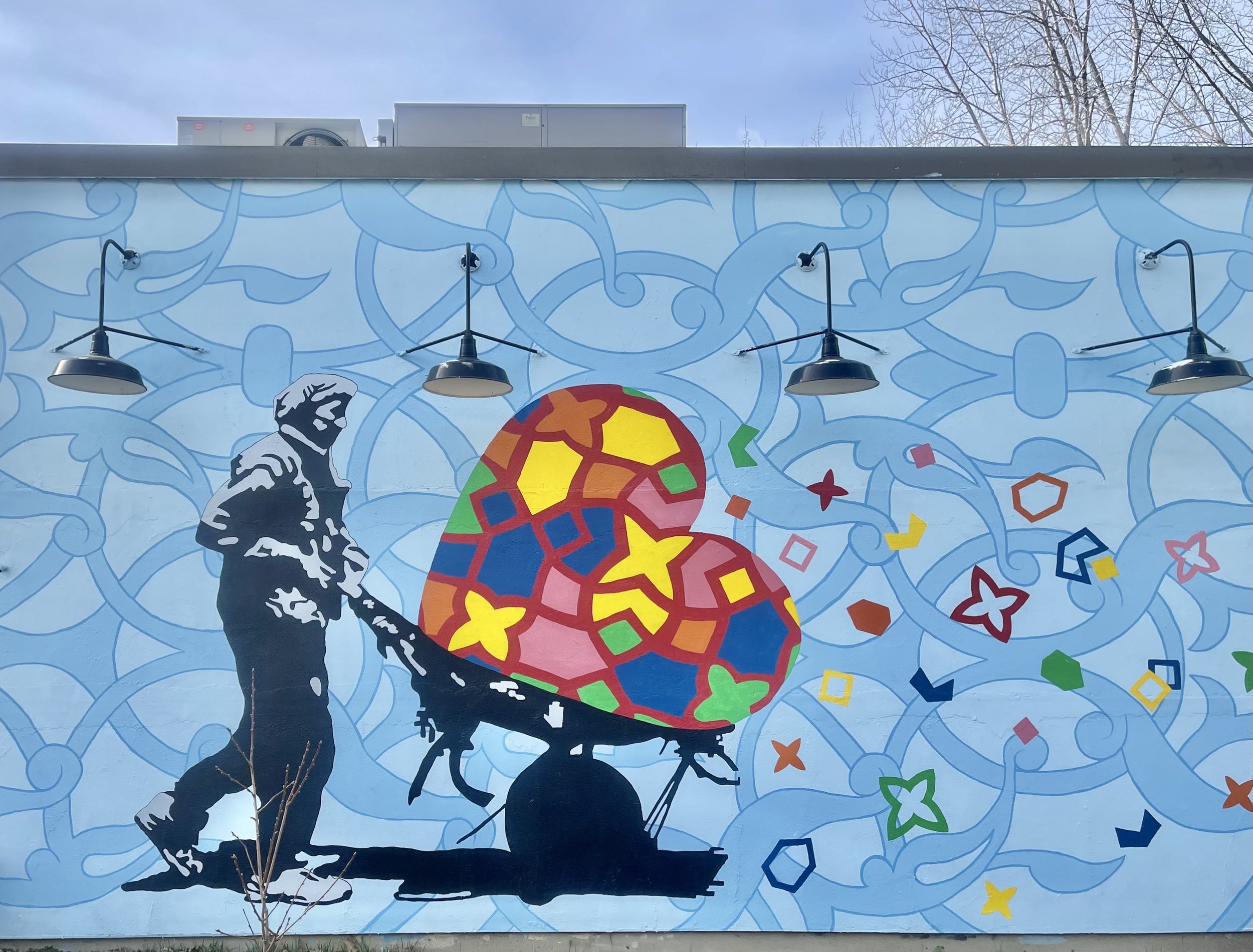 This mural at Foodworks, one of the food pantries in Brattleboro, shows a worker carrying "love and harmony," according to one of the ArtLords members who painted it.
