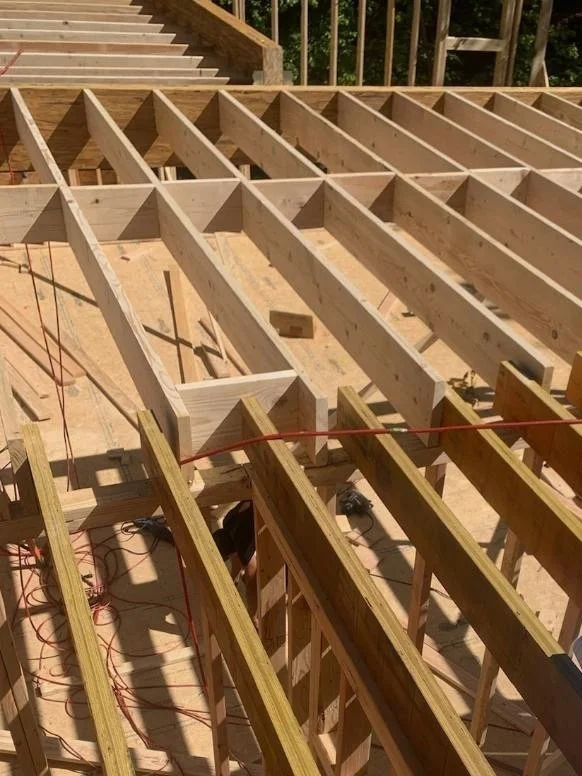 Wooden floor joists under construction with a red string line