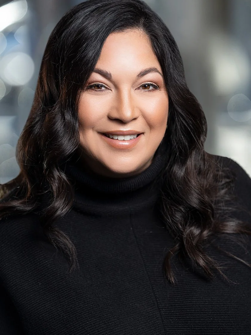 Smiling woman with long dark hair wearing a black top