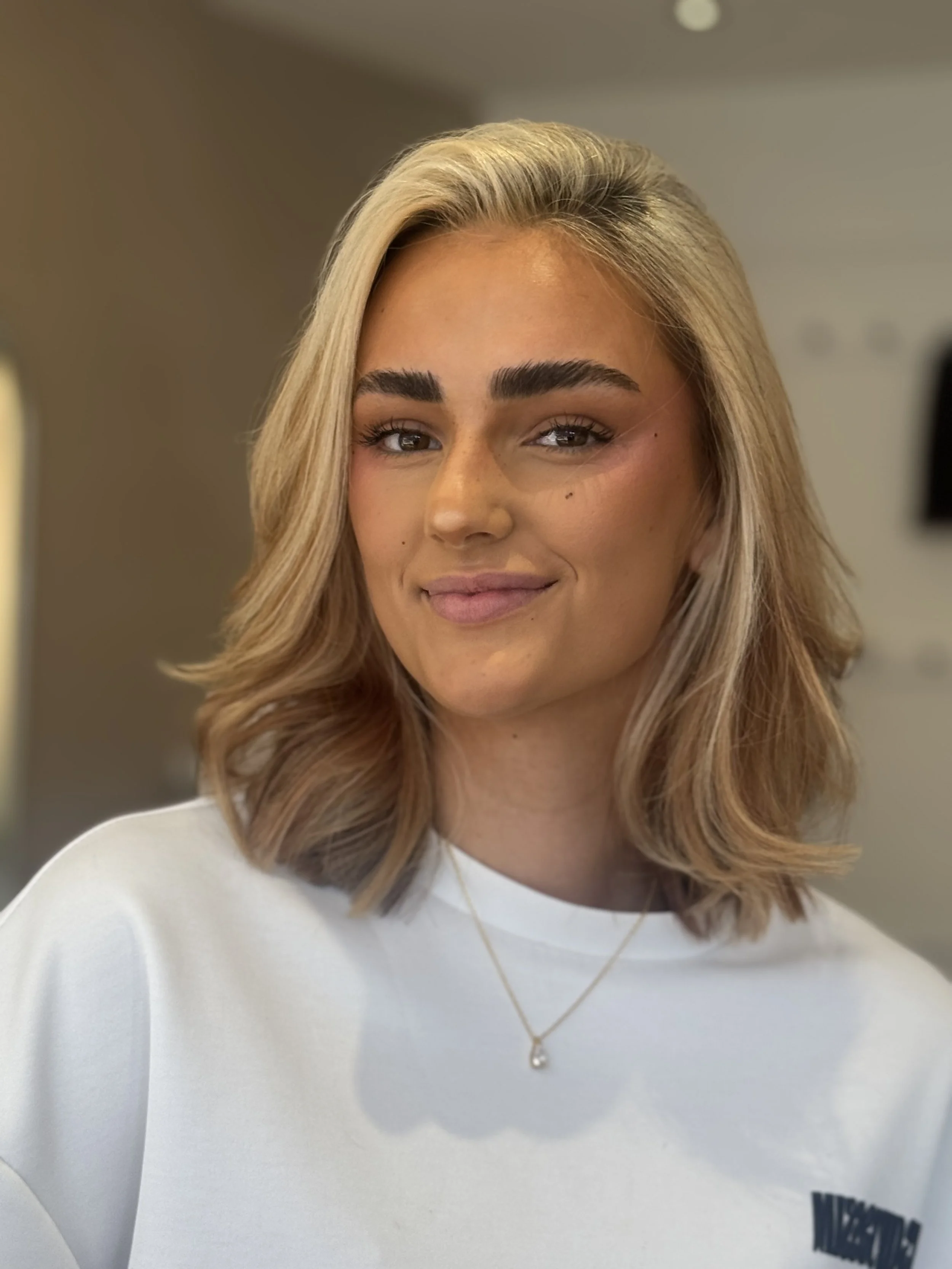 Blonde lob met naar binnen gedraaide punten, geknipt en gestyled in de salon