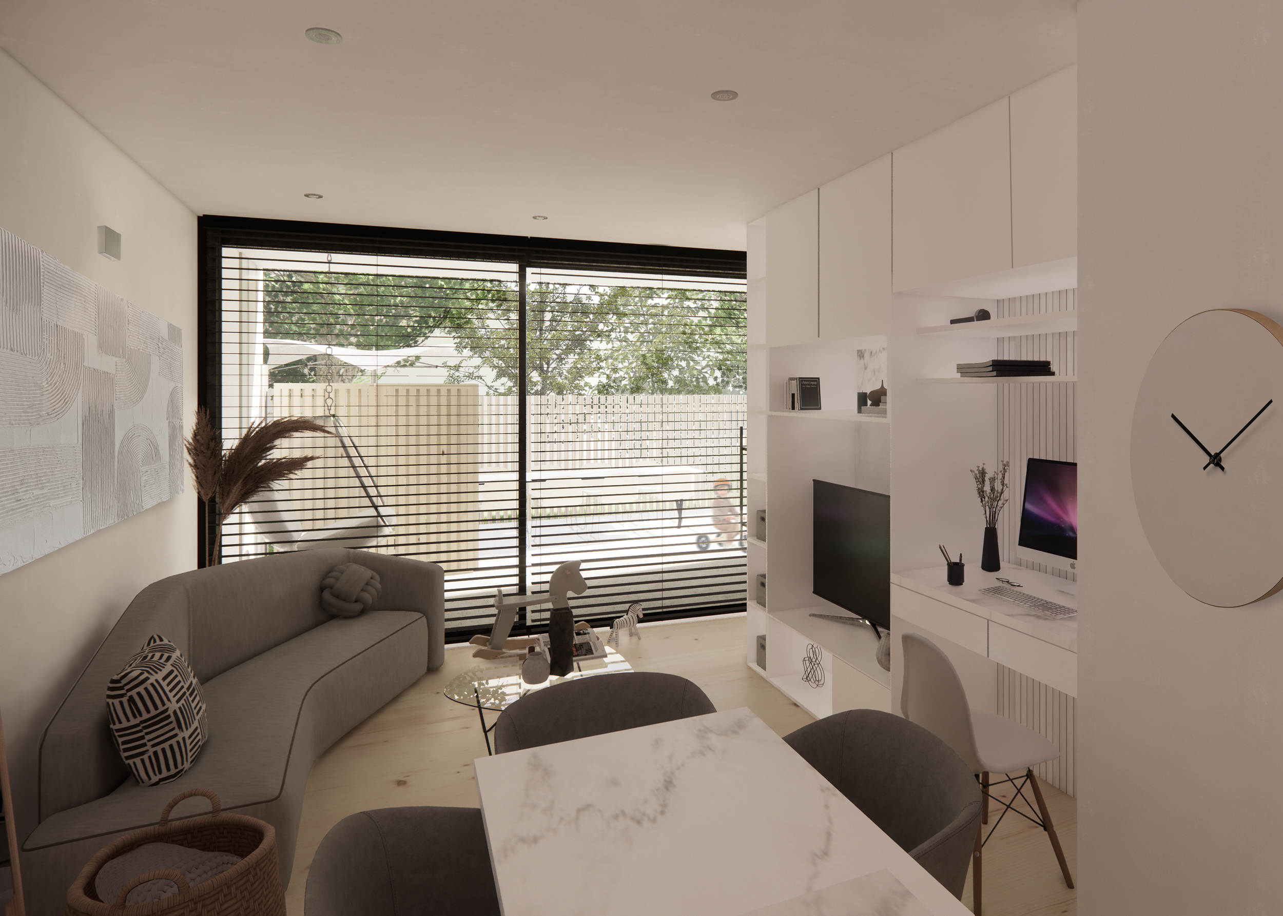 Modern living room with gray sofa, glass coffee table, wall-mounted TV, built-in desk with computer, large windows with blinds, and minimalistic decor.