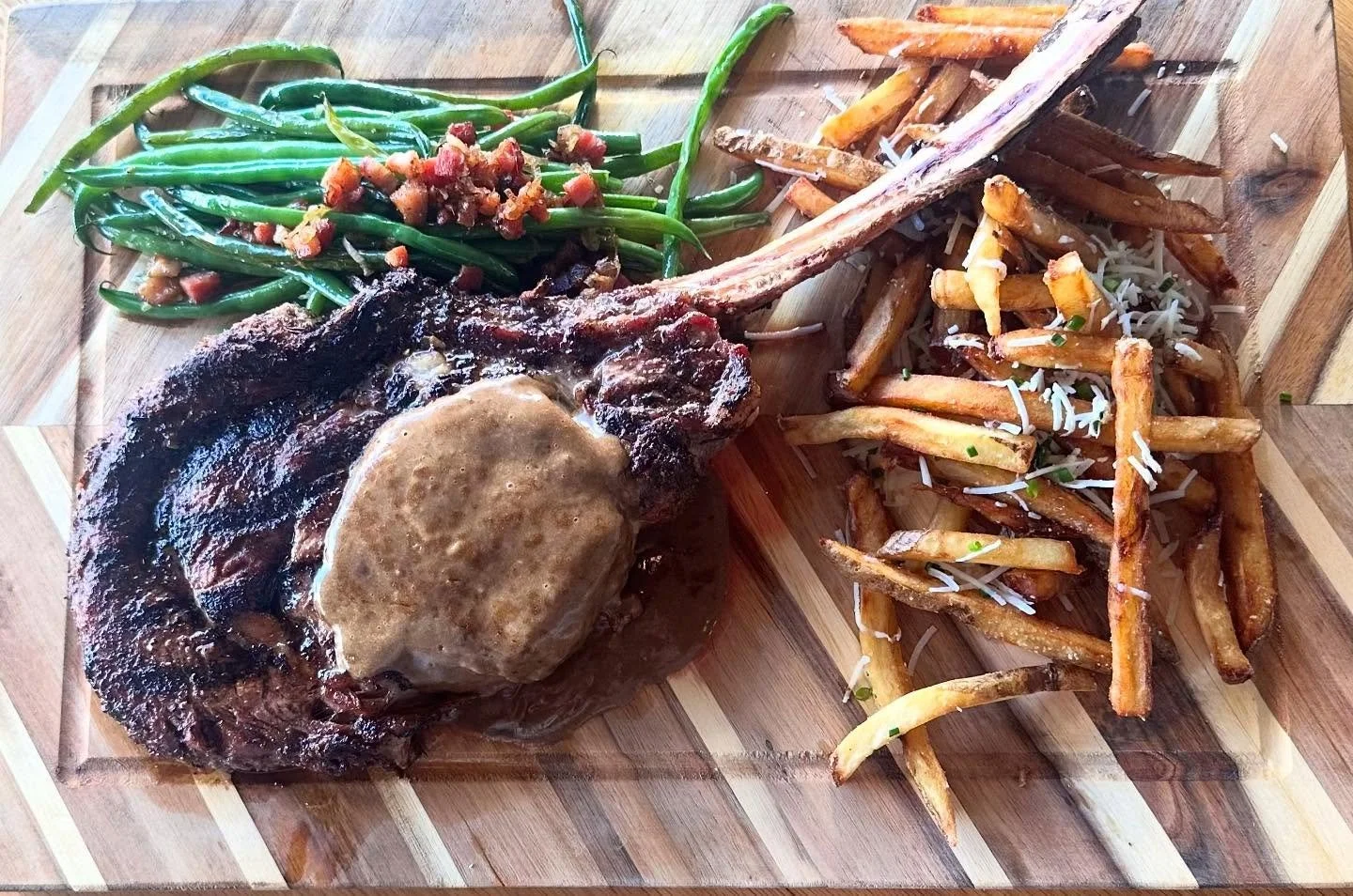 New Year&rsquo;s Eve board 😚👌38 oz tomahawk, seasoned with local mushroom powder, black garlic truffle hollandaise, beef tallow parmesan chive fries, bacon and shallot haricot verts. End the year right 🎉