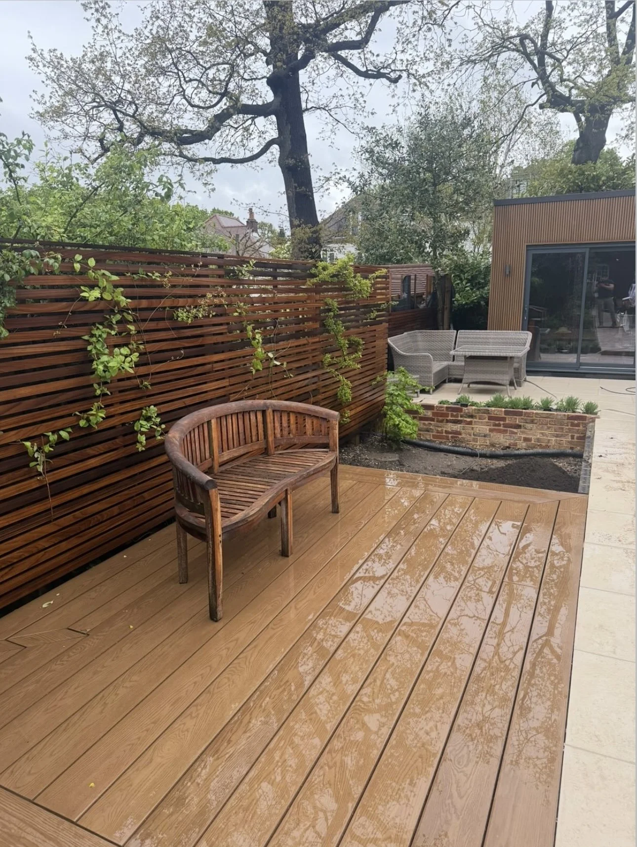 Winchmore Hill garden with wood decking, fenced area, paving, and space for planting
