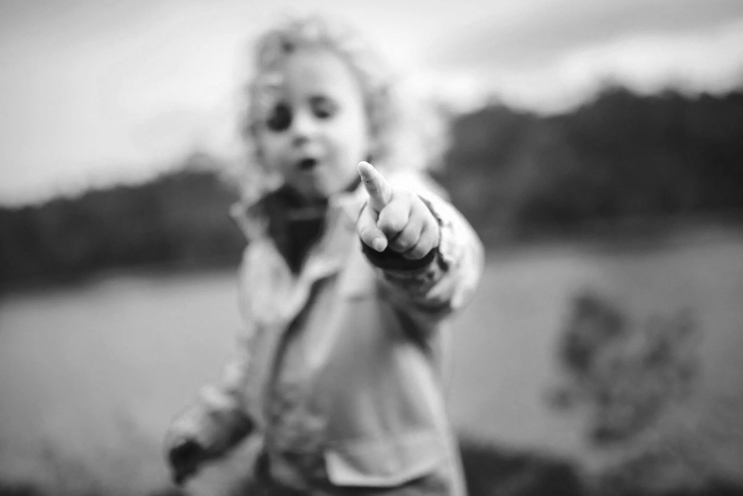 Close-up of a young child pointing with curiosity, symbolizing emotional expressiveness, sensitivity, and the wonder of childhood.