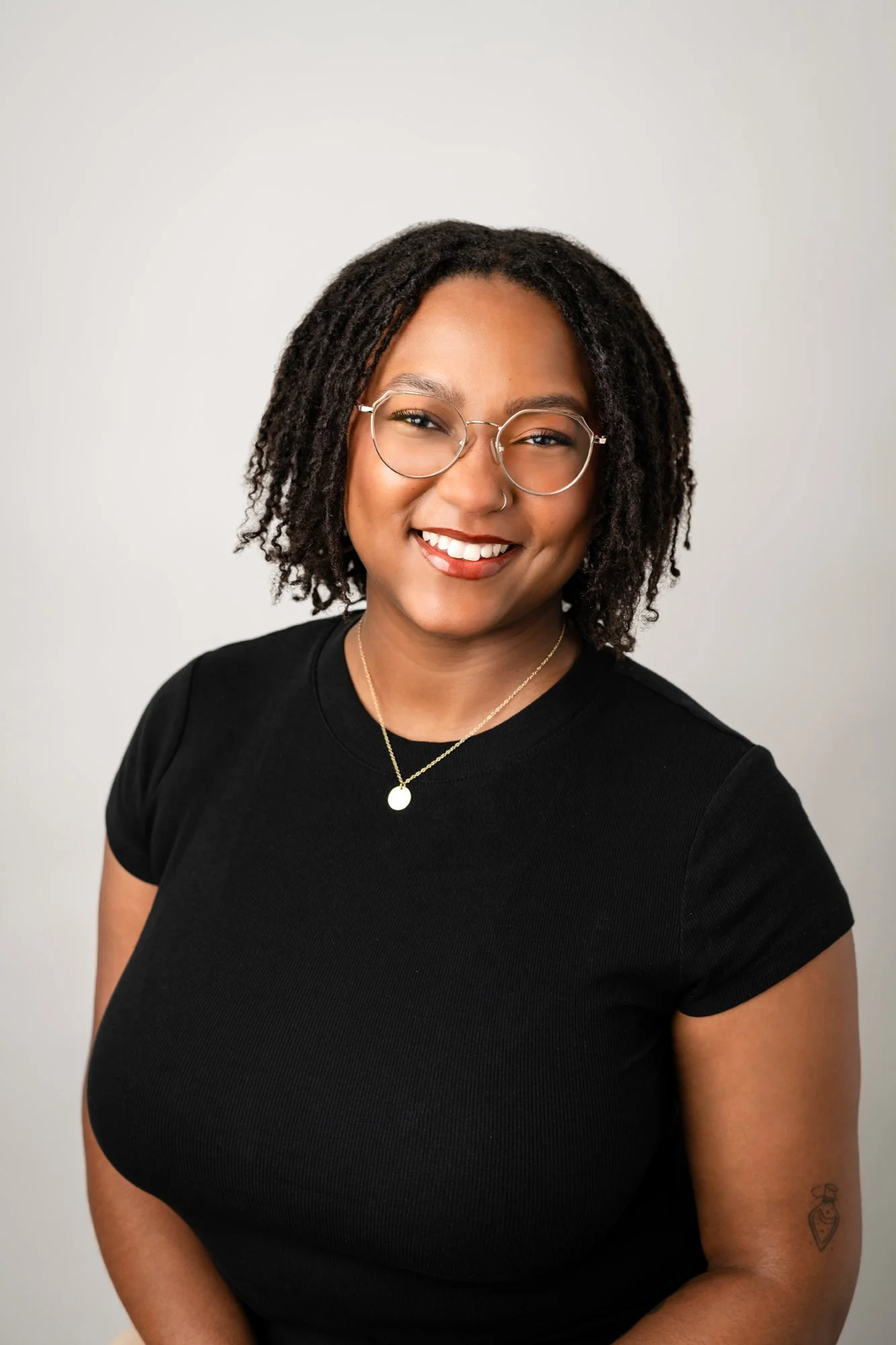 smiling woman in black with glasses for team headshot day