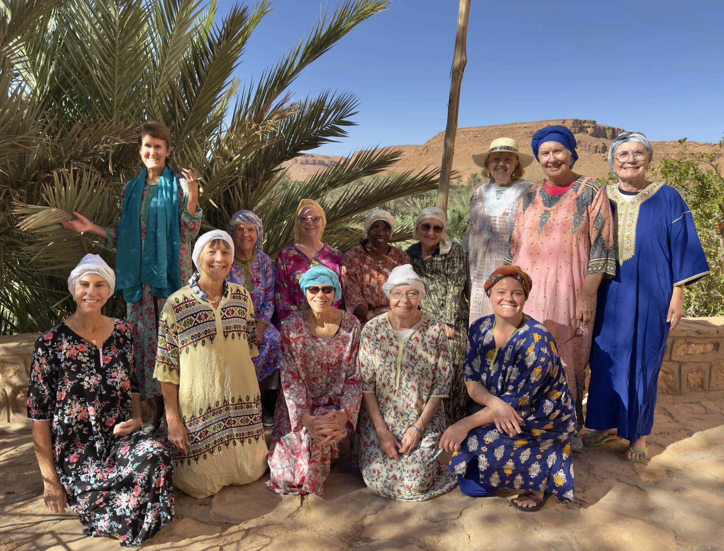 women dressed in traditional moroccan clothing at an oasis
