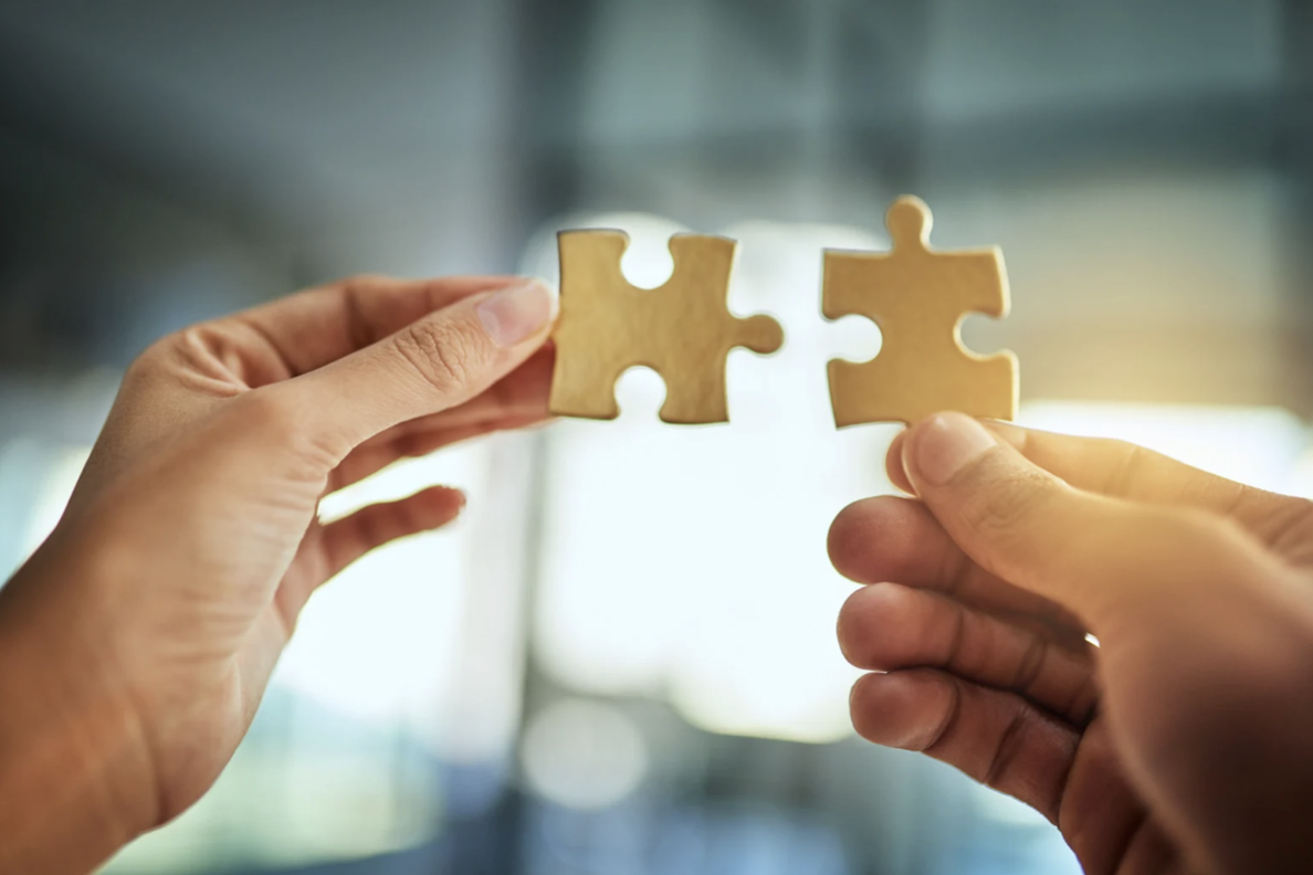 Two hands holding two puzzle pieces connecting in the center representing "just right" OCD.