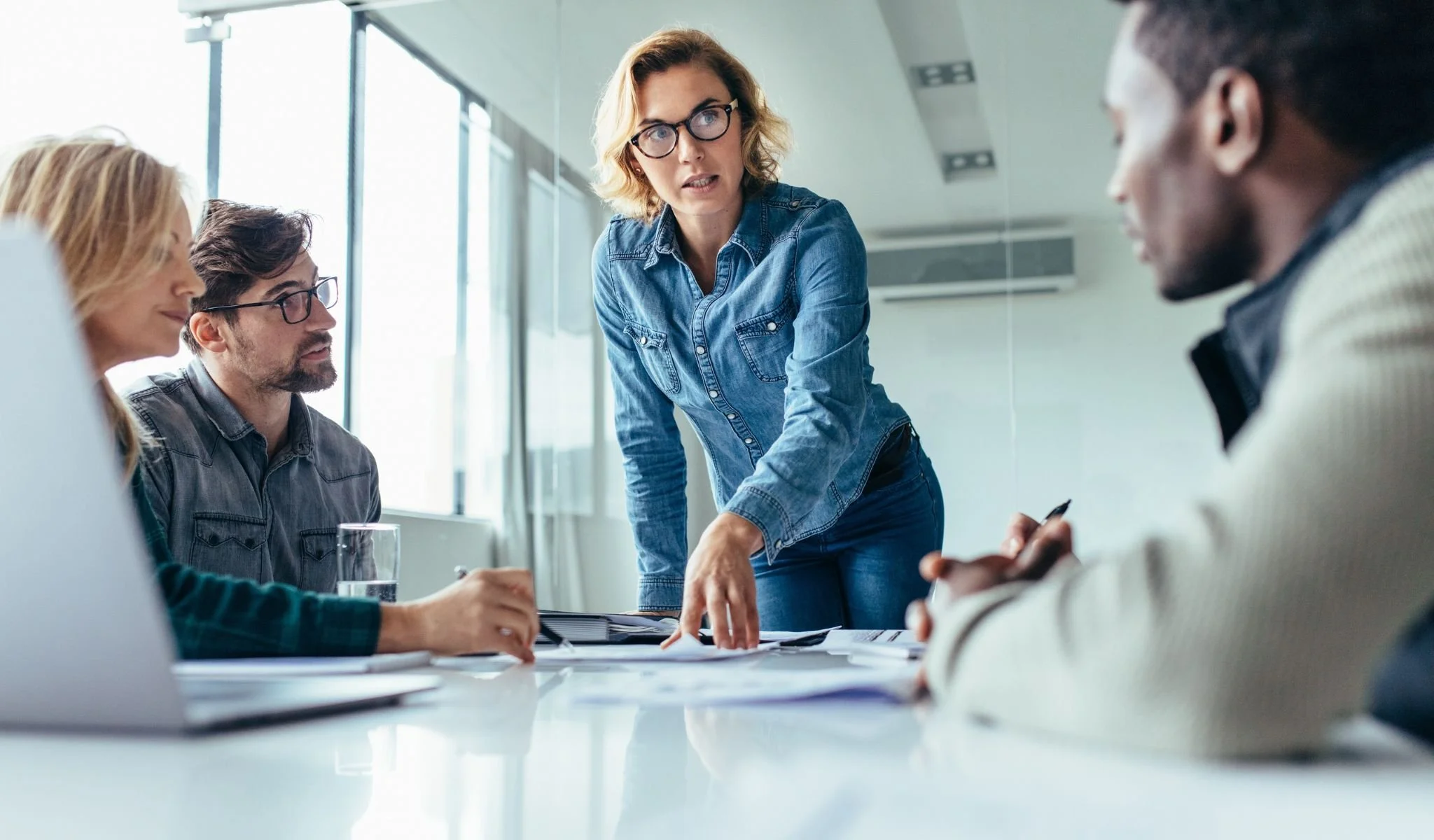 Executive leadership team discussing hiring strategy and business decisions in a boardroom setting