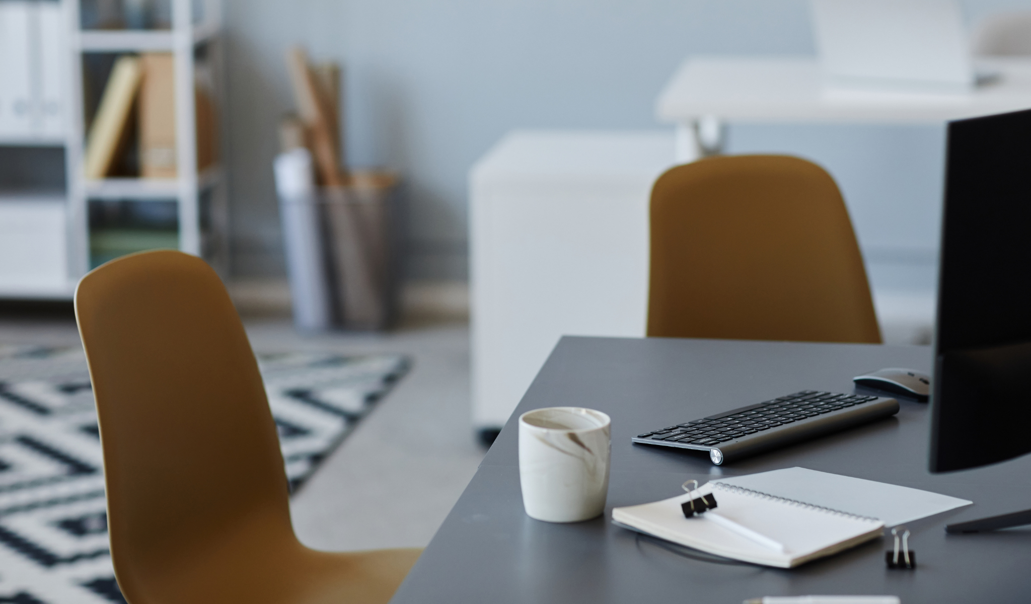 Empty office desk with keyboard, notebook, and coffee cup — representing employee turnover and the cost of poor leadership communication