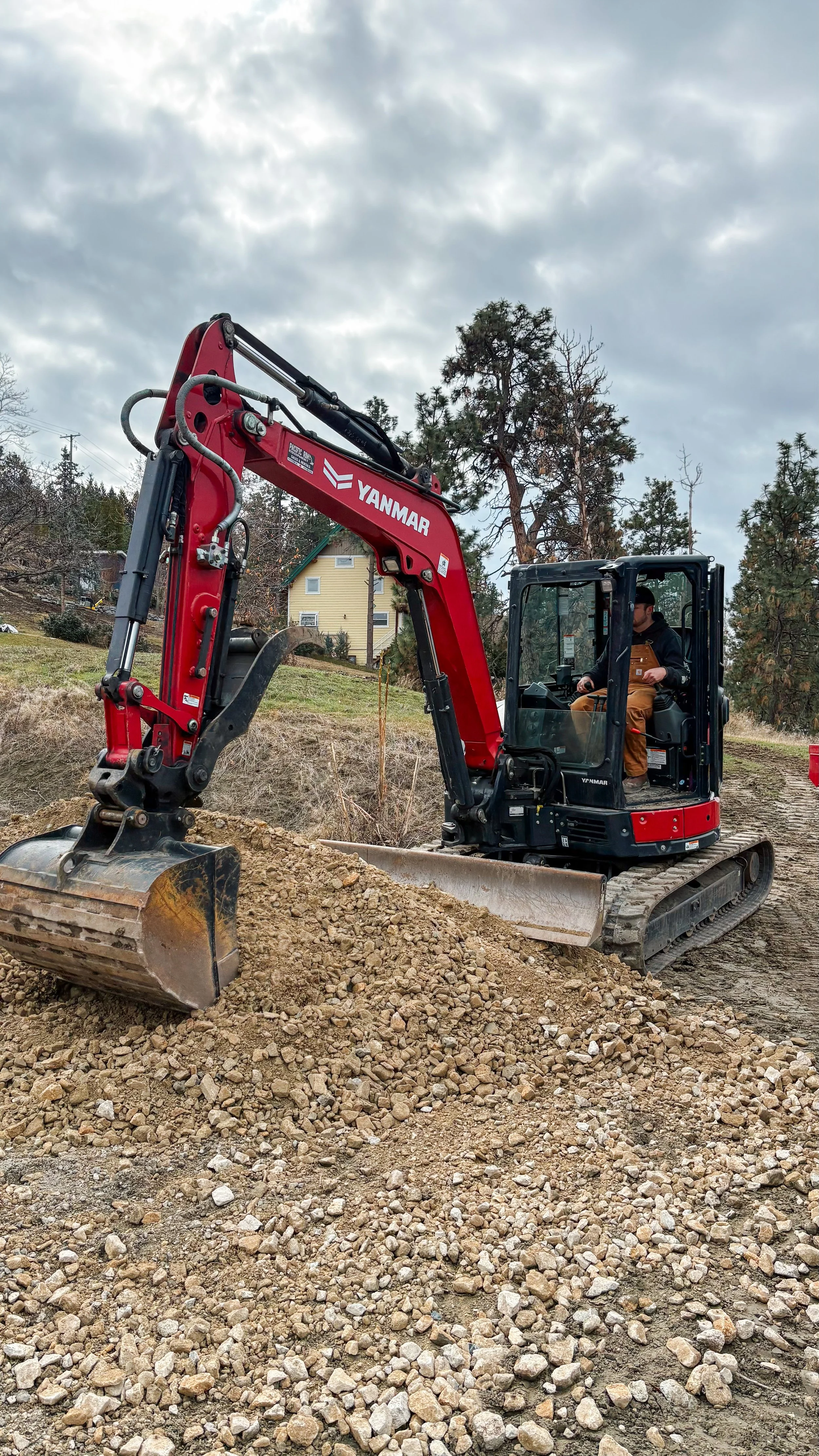 Red Yanmar excavator moving dirt on a construction site