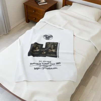 Bed with a white towel featuring printed text and images, including a book and a reference to J.C. Evryn.