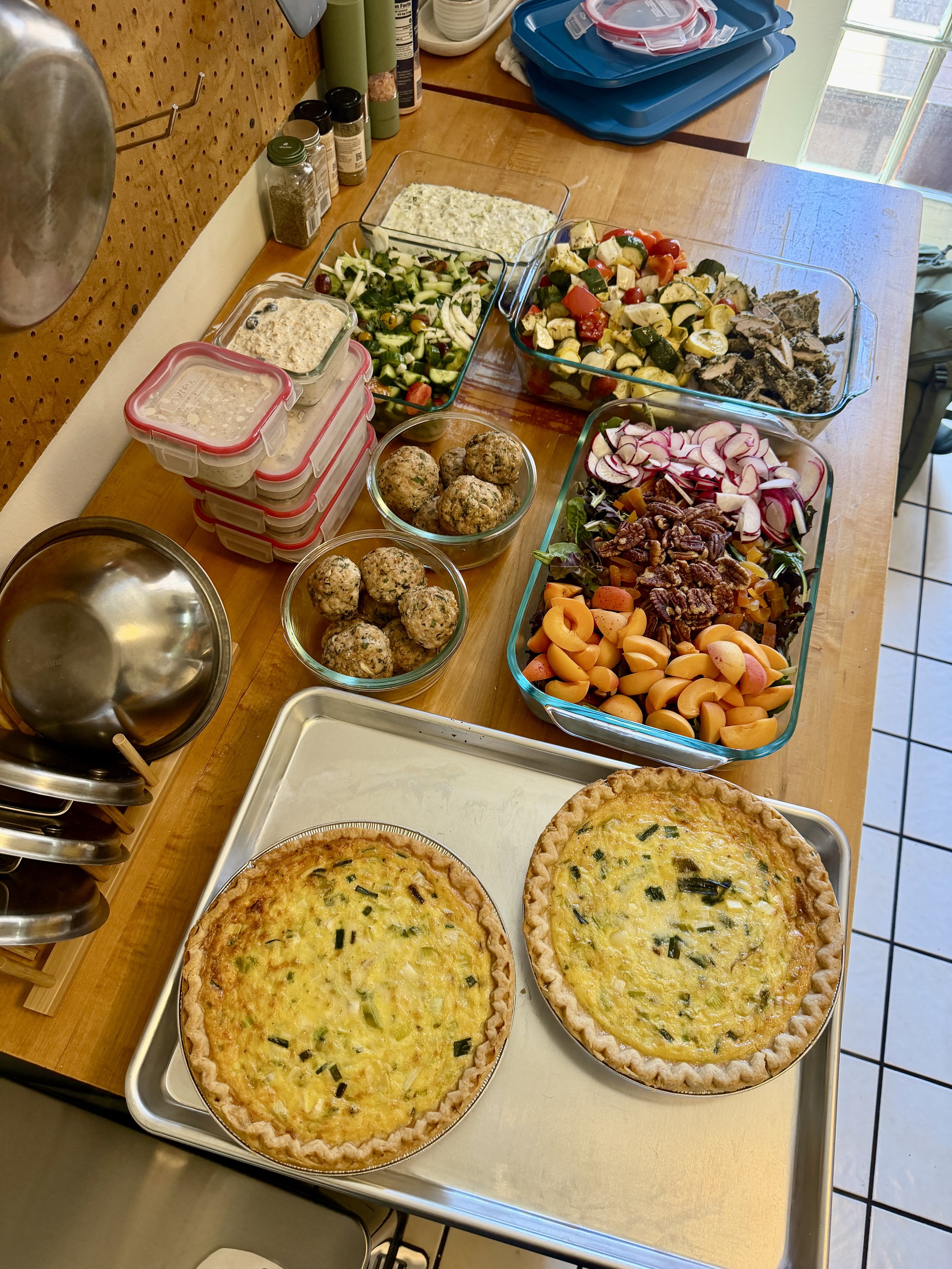 Two homemade quiches with a golden crust and green onion garnished on a rectangular baking sheet.