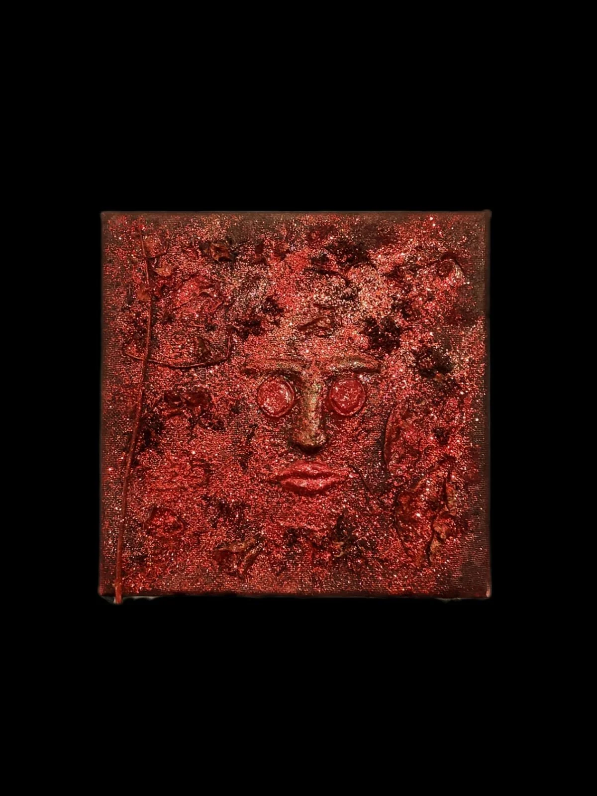 Textured artwork with red tones resembling a face on a black background.