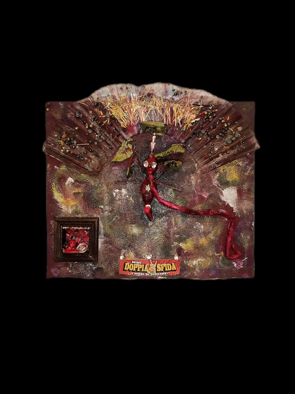 Abstract artwork featuring a textured canvas with mixed media elements, including a central red creature and various embellishments. The design includes a label with text "MINI DOPPIA SFIDA" and colorful patterns.