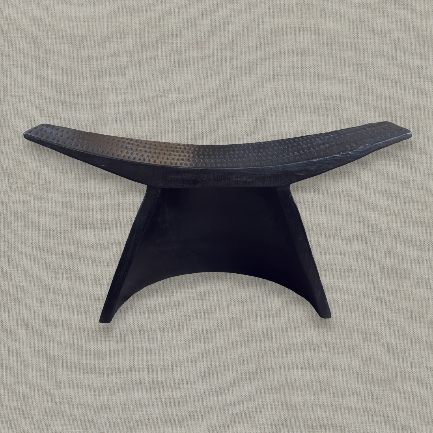 Sculptural mango wood bench with curved seat and carved details in matte black finish styled for modern interior in California