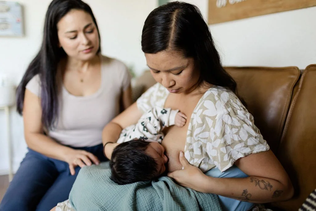 Lactation consultant helping a mom breastfeed.
