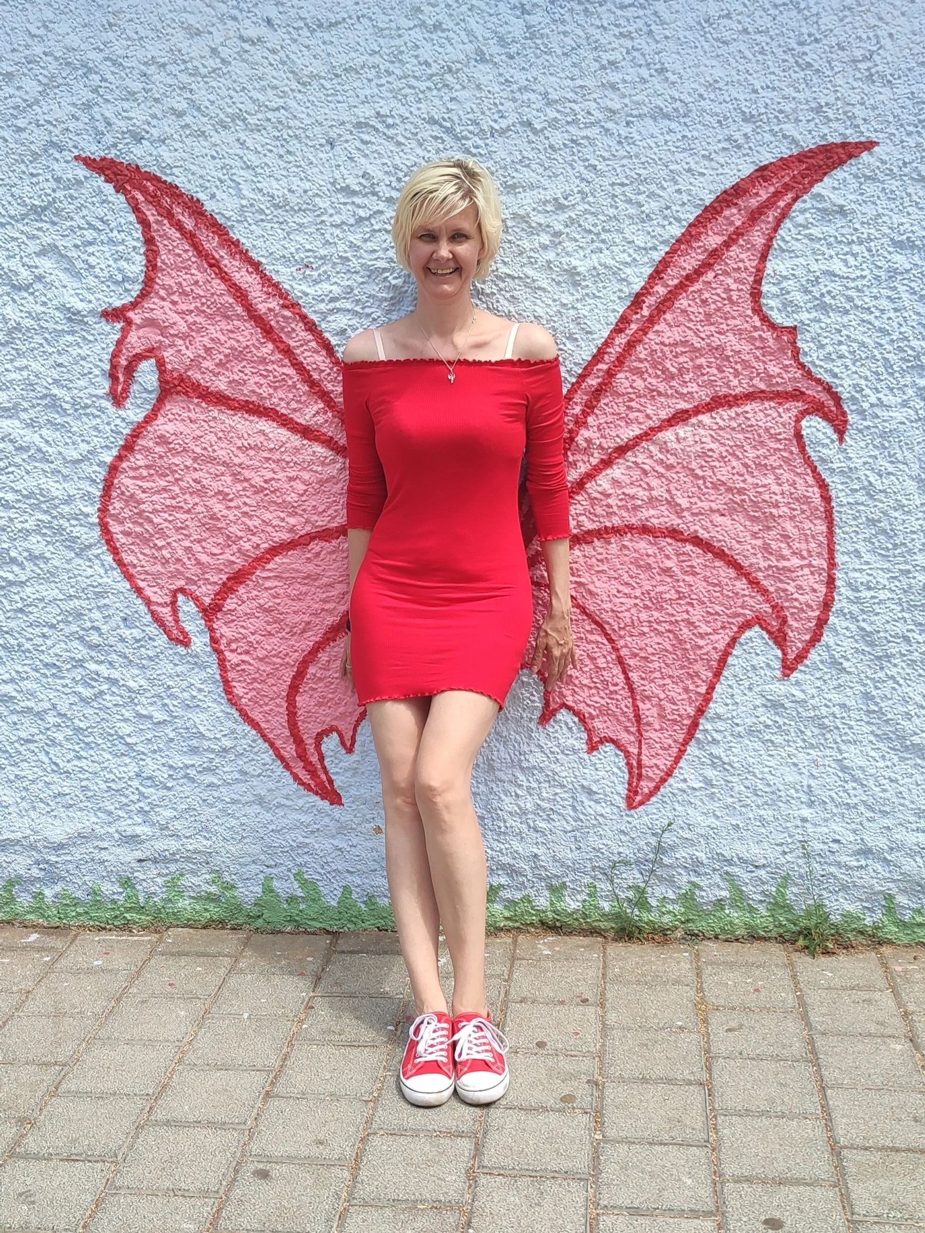 Person in red dress with wings mural