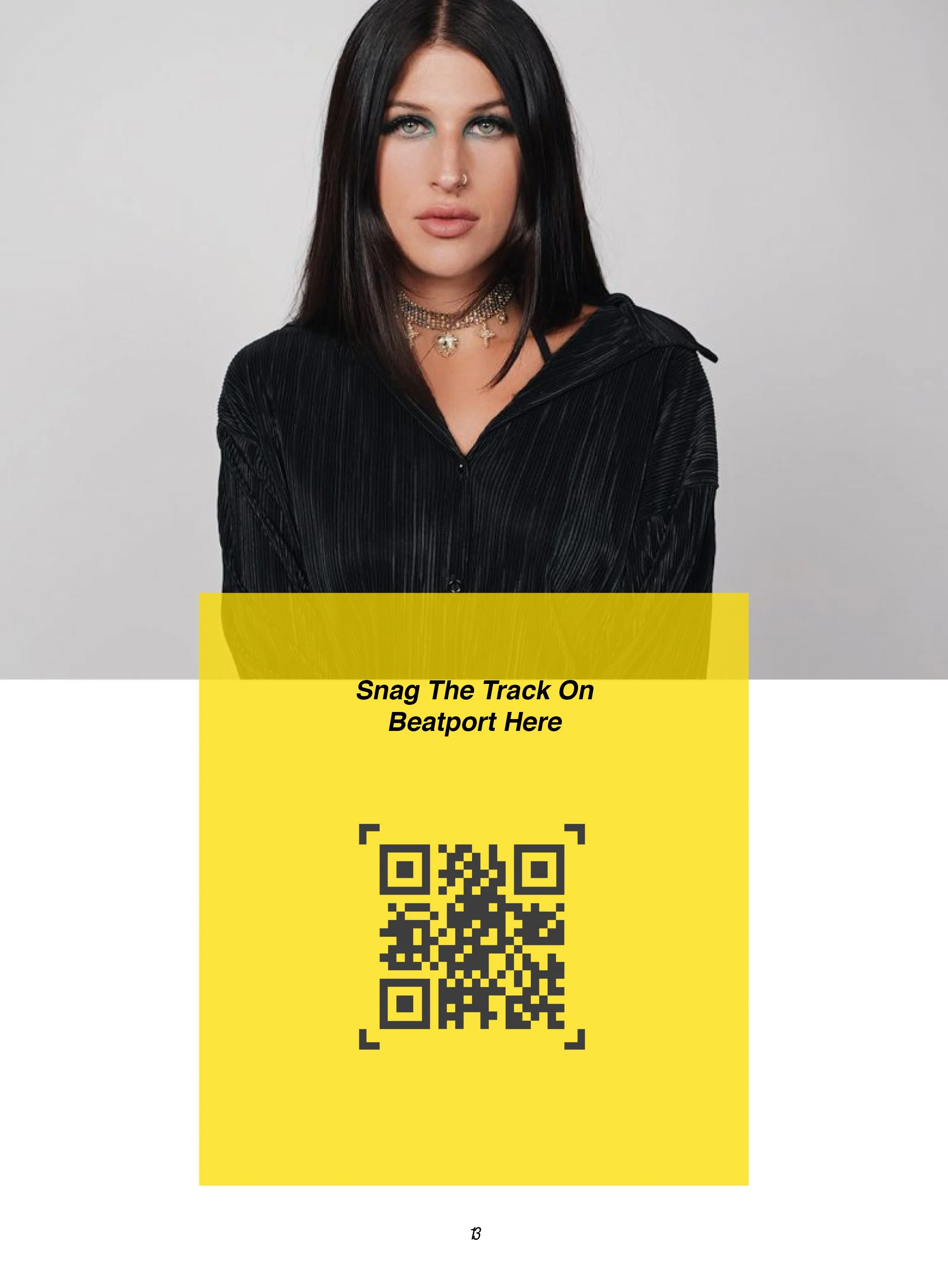 A woman with dark hair, wearing a black top with a zipper, a nose ring, and multiple layered necklaces, standing against a plain white background.