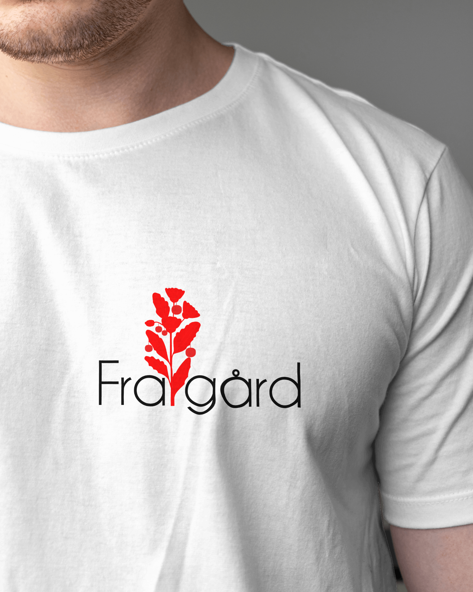 White T-shirt with a red leaf and flower design above the word 'Frågard' in black text.