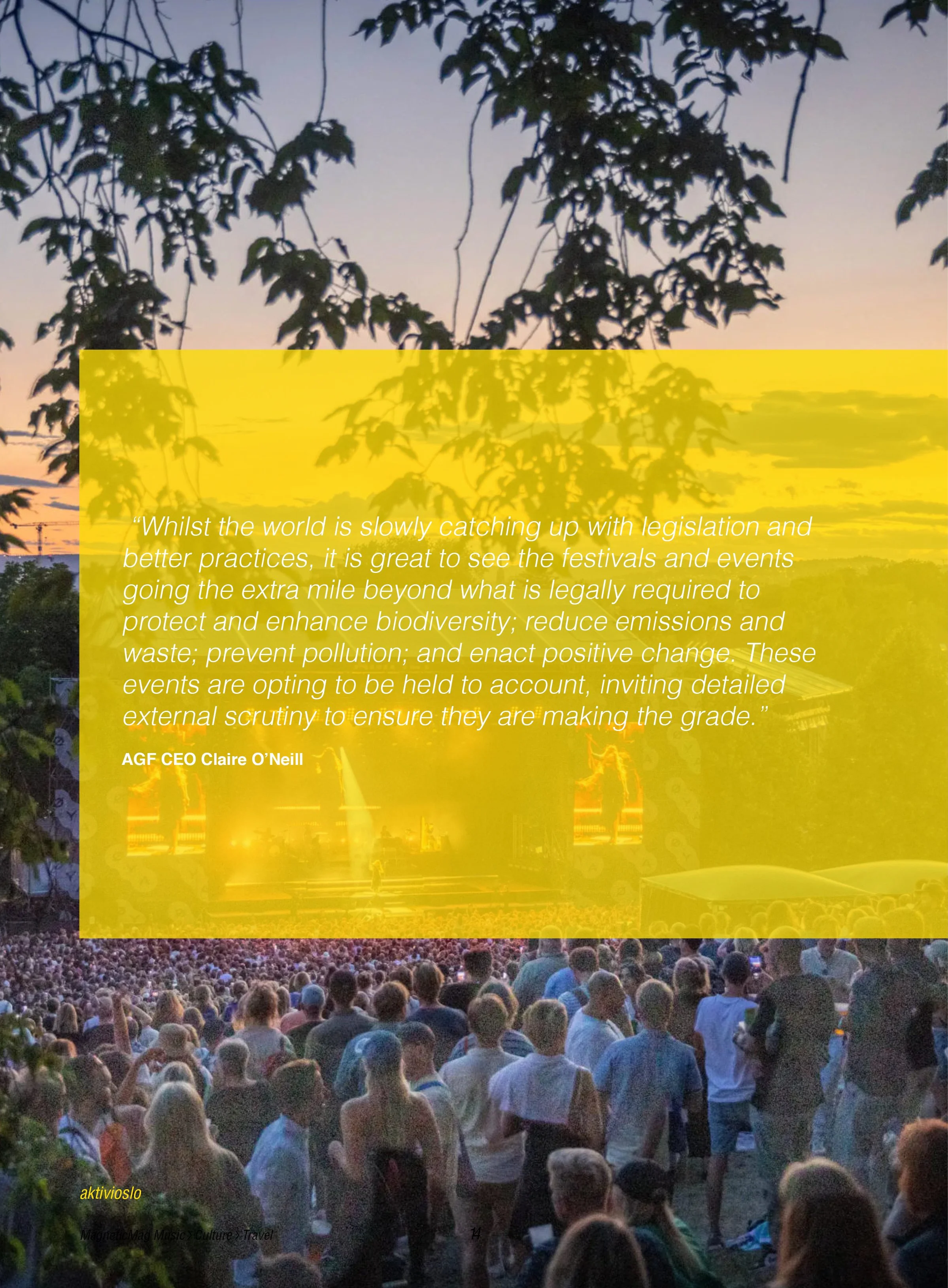 A large outdoor concert audience facing a brightly lit stage with a sunset sky in the background.