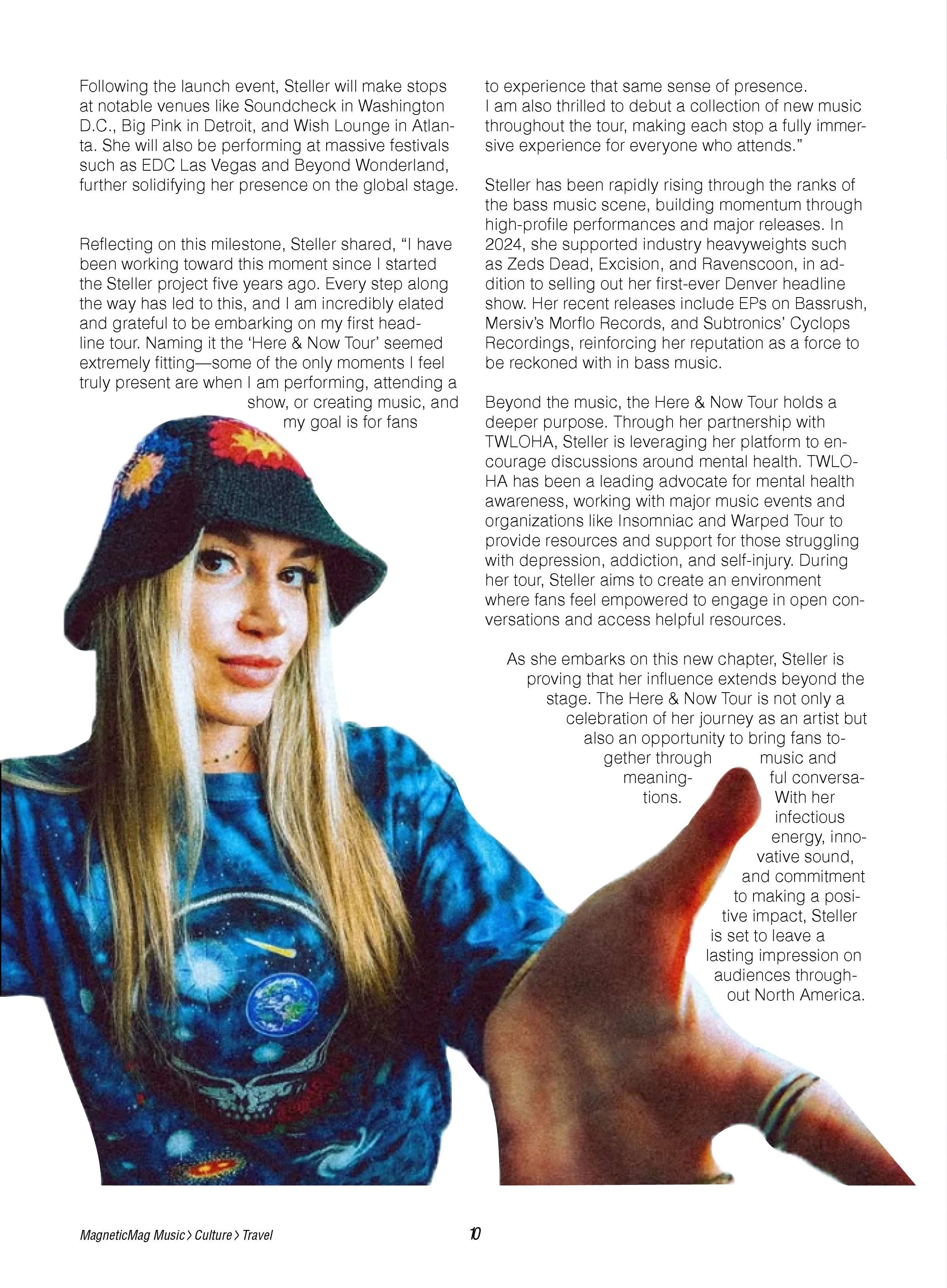 A young woman with long blonde hair wearing a dark hat with colorful designs and a blue tie-dye shirt with an Earth-shaped button, reaching out with her right hand.