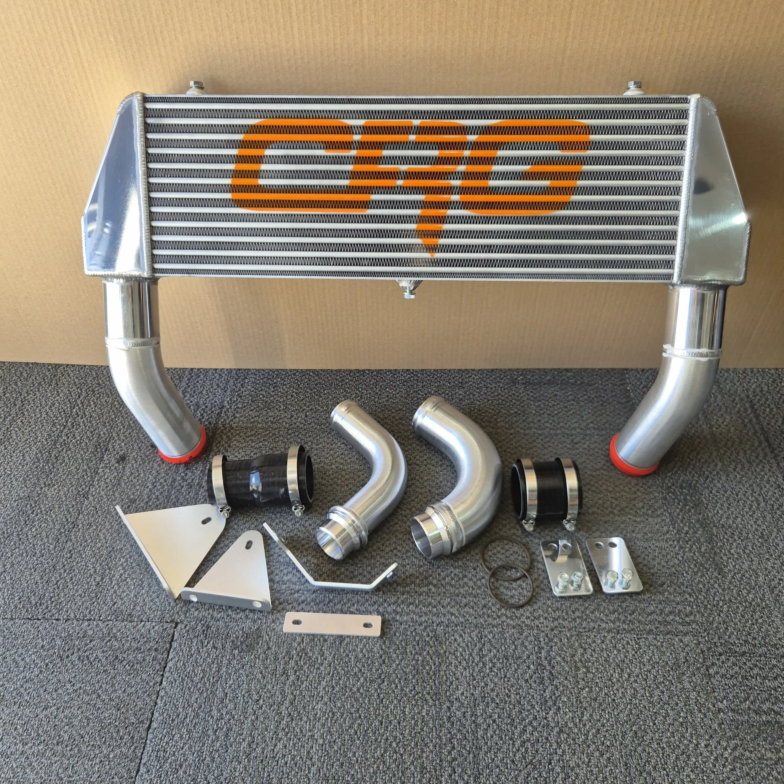 A car intercooler with attached hoses and mounting hardware