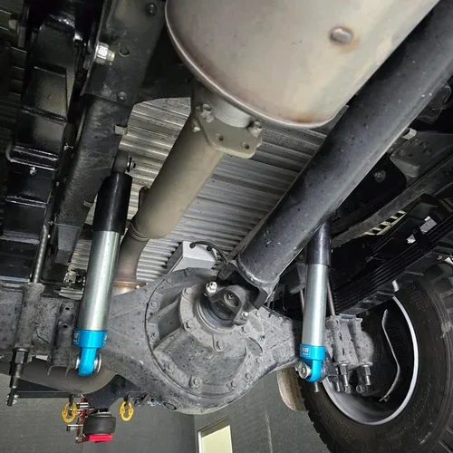 Underneath view of a vehicle showing differential, suspension parts, and wheel.