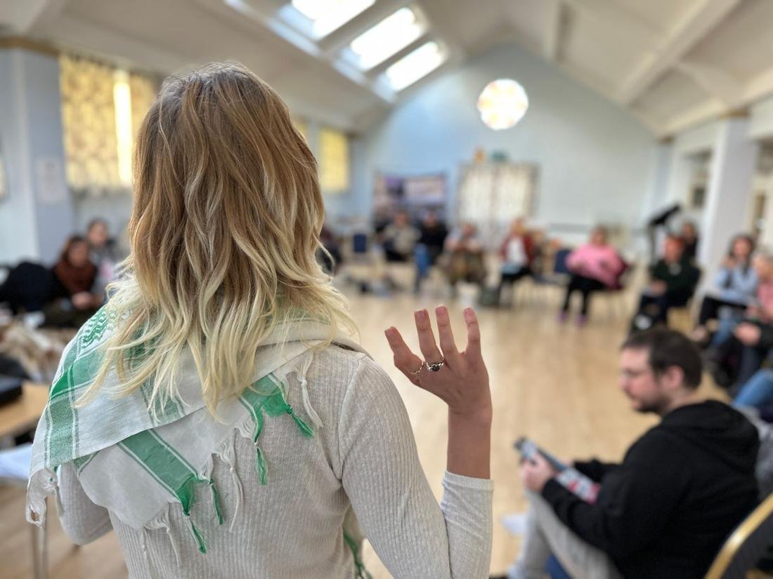 An organiser leads a training session for a room of activists at a regional bootcamp