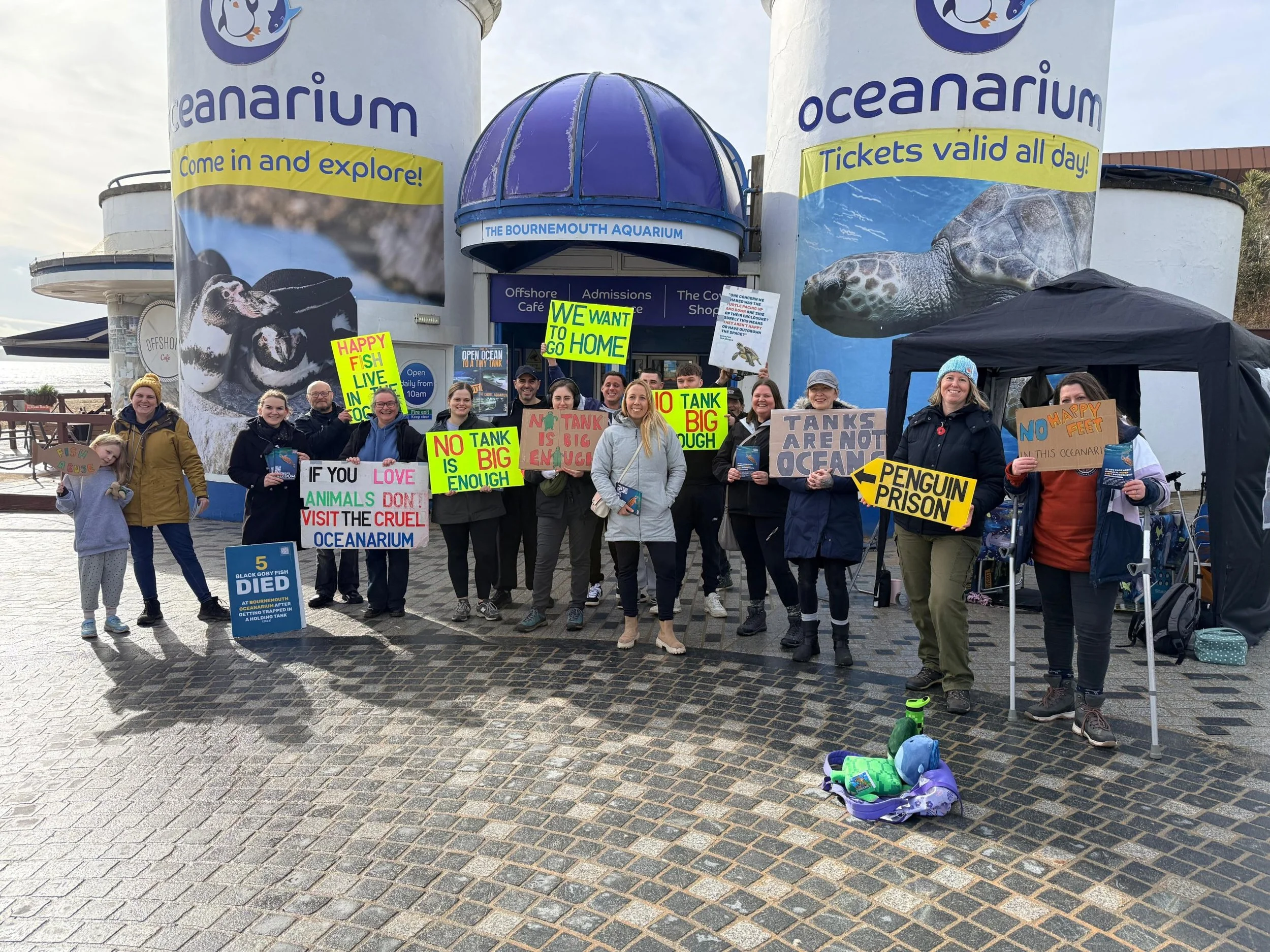 A local animal freedom group smiling with homemade placards outside an aquarium in Bournemouth