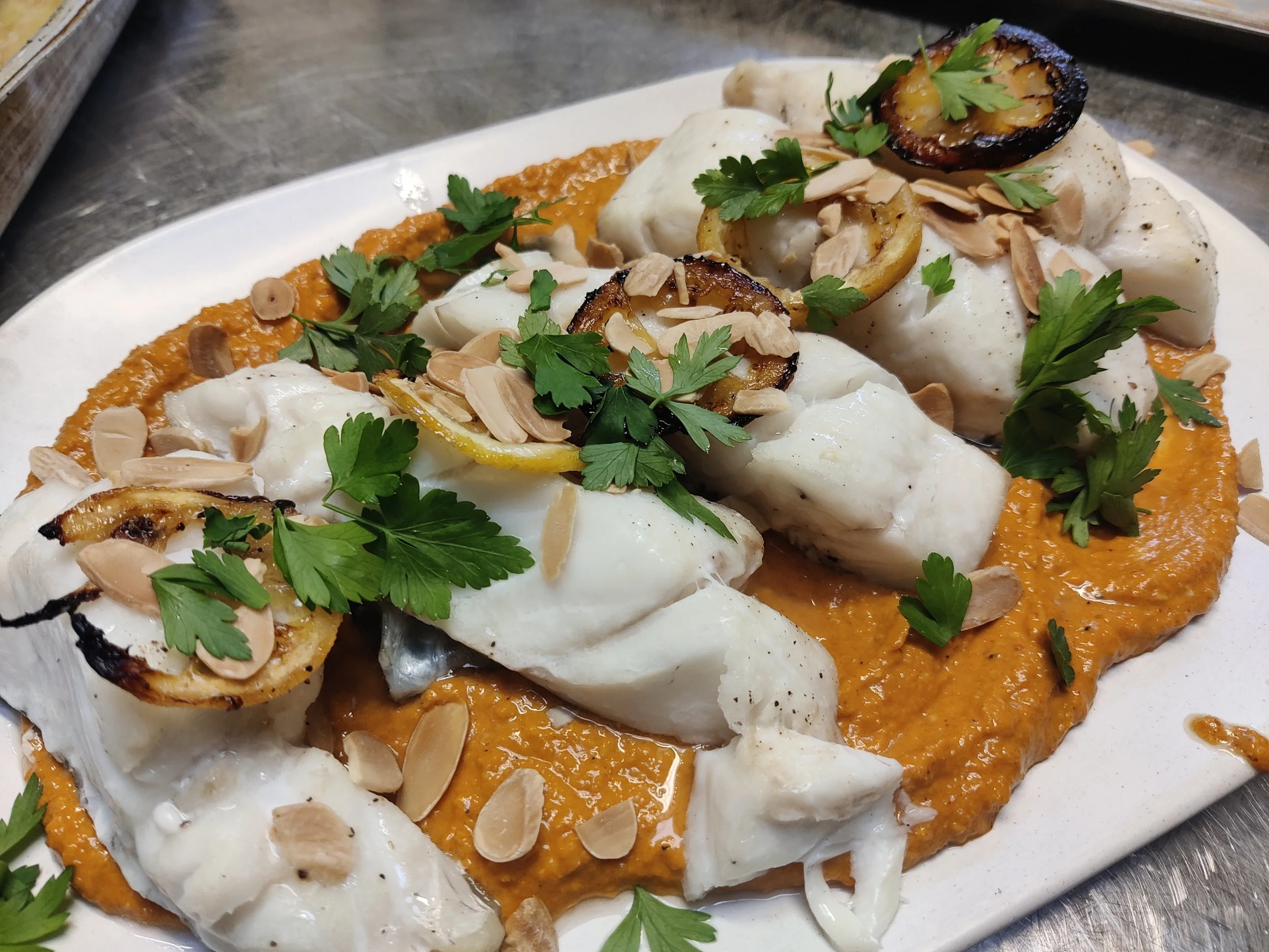 Cod with romesco, grilled lemons and toasted almonds
