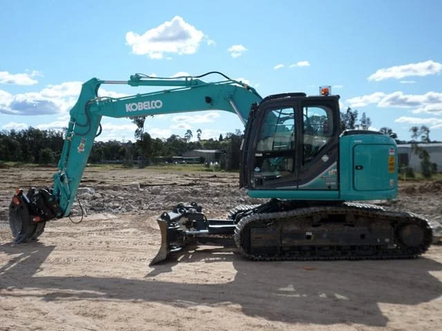 Escavatore blu su un cantiere edile.