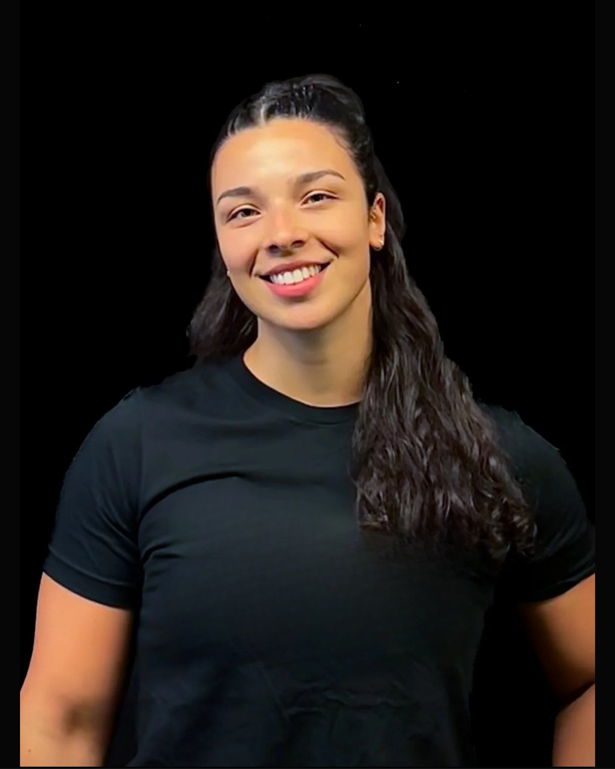 Person wearing a black T-shirt, smiling, with dark background.