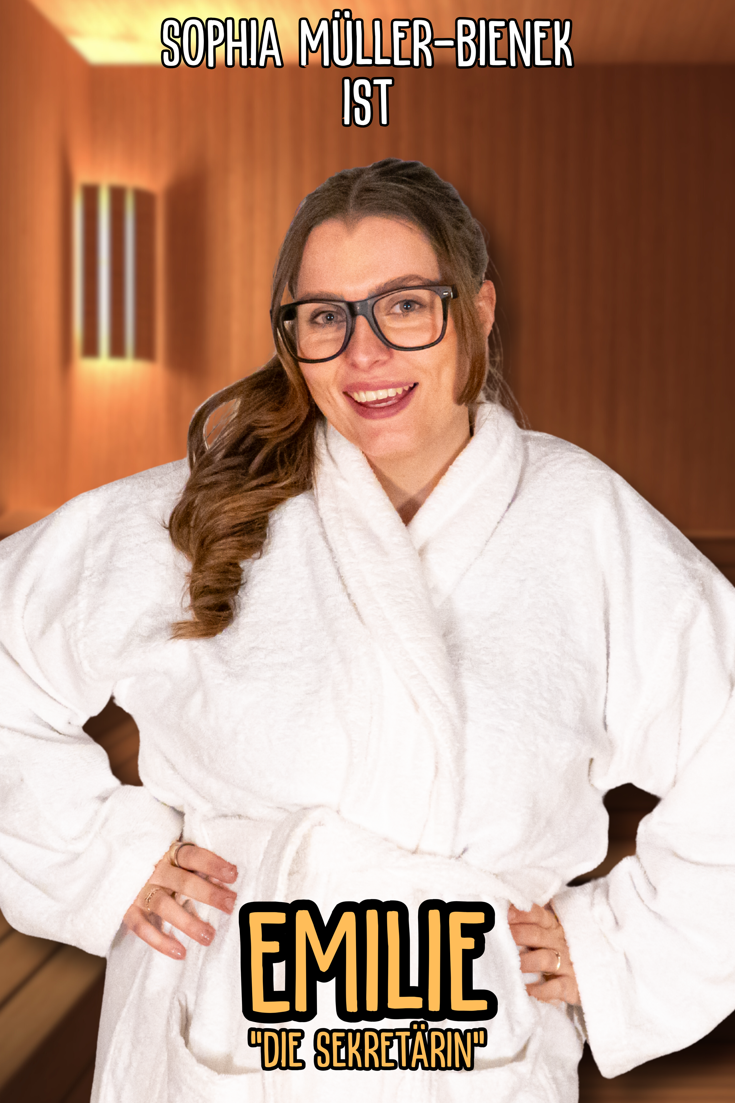 Eine lachende Frau mit Brille in einem weißen Bademantel steht in einer Sauna oder einem Spa-Bereich, hinter ihr Holzwände und eine Lichtlampe an der Wand.